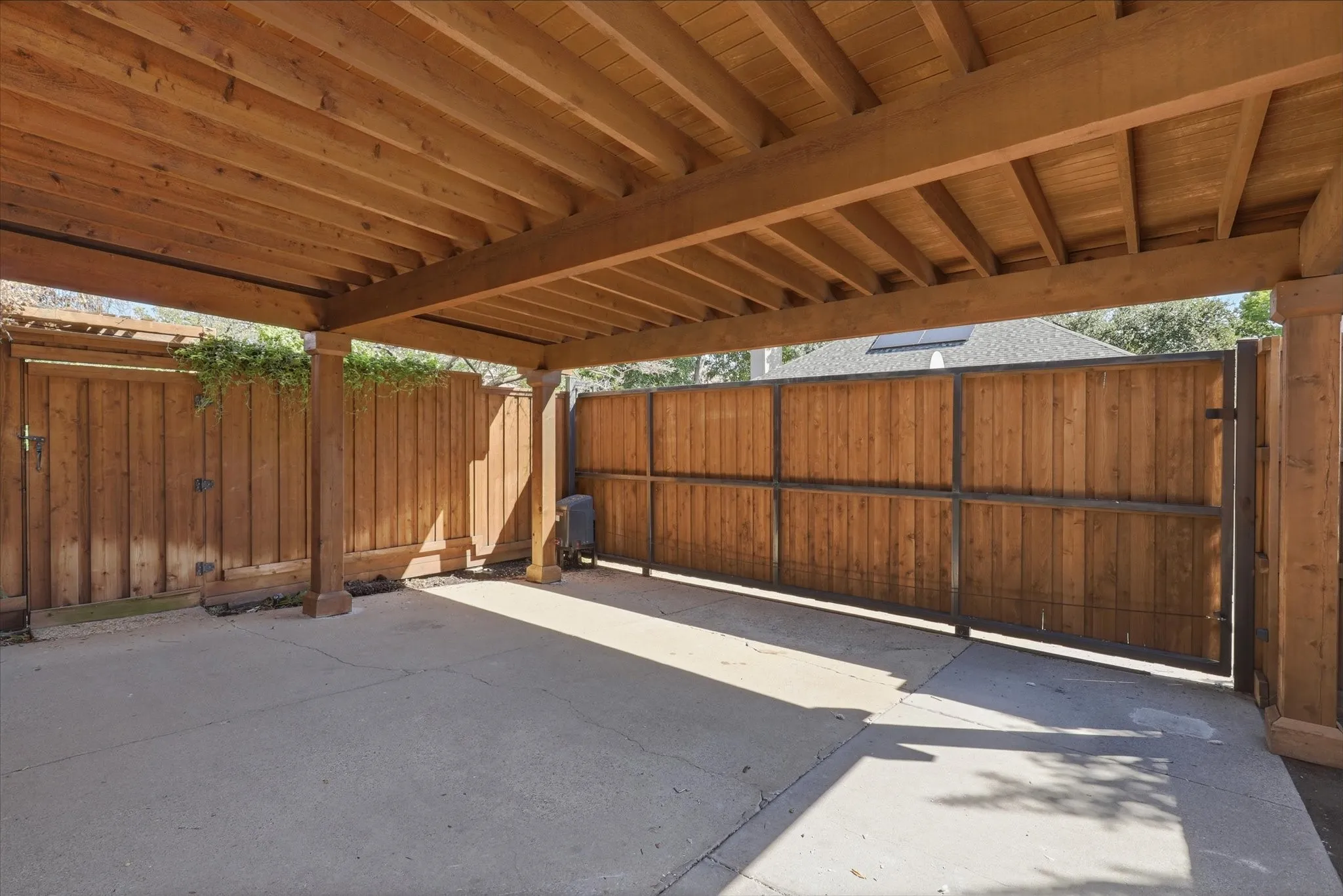 Beautifully constructed carport and an electric gate across the driveway
