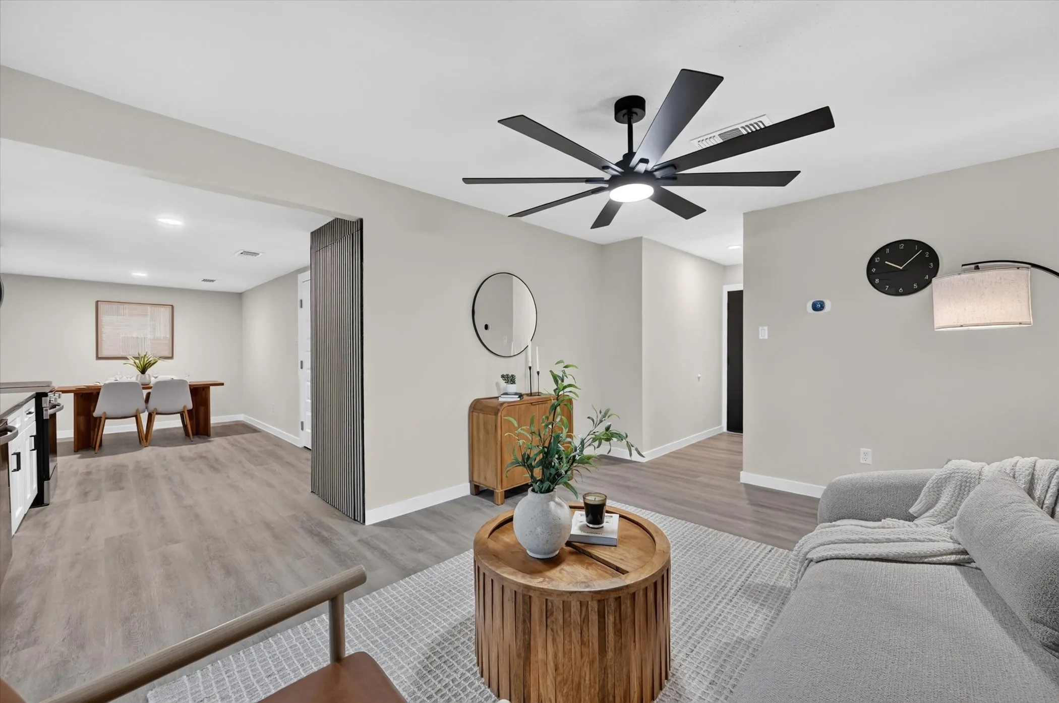 Wood-finish flooring throughout, modern black ceiling fan, recessed lighting, and light neutral wall colors