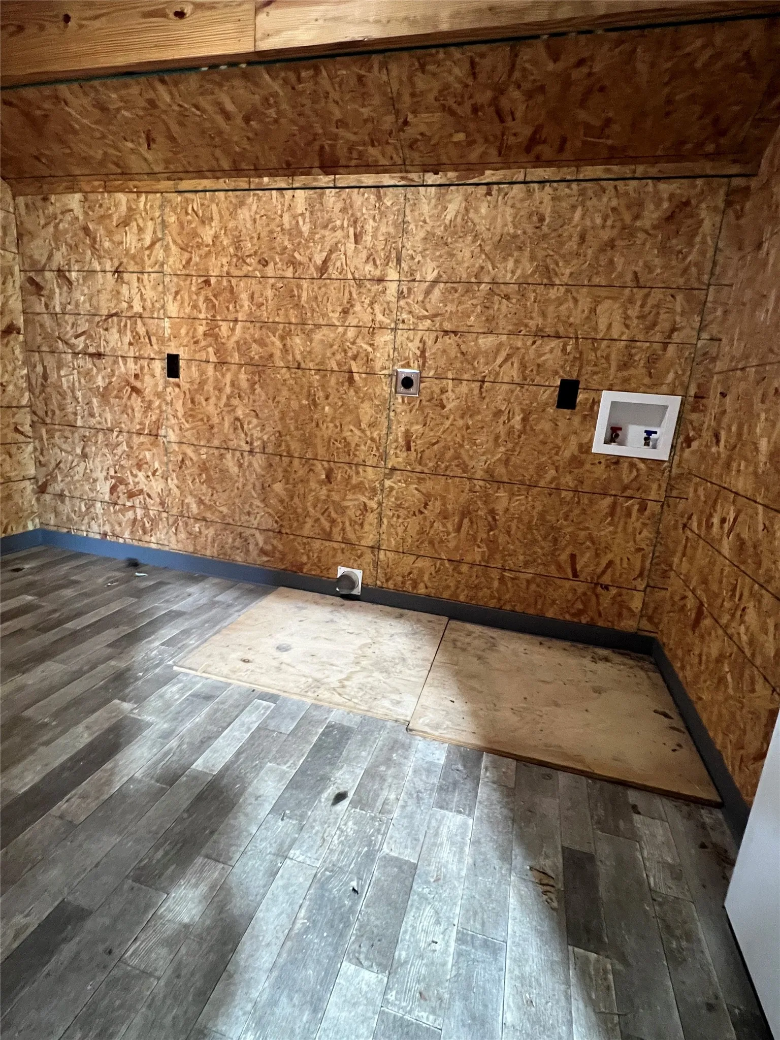 Storage room next to dog wash station has washer and dryer hook ups