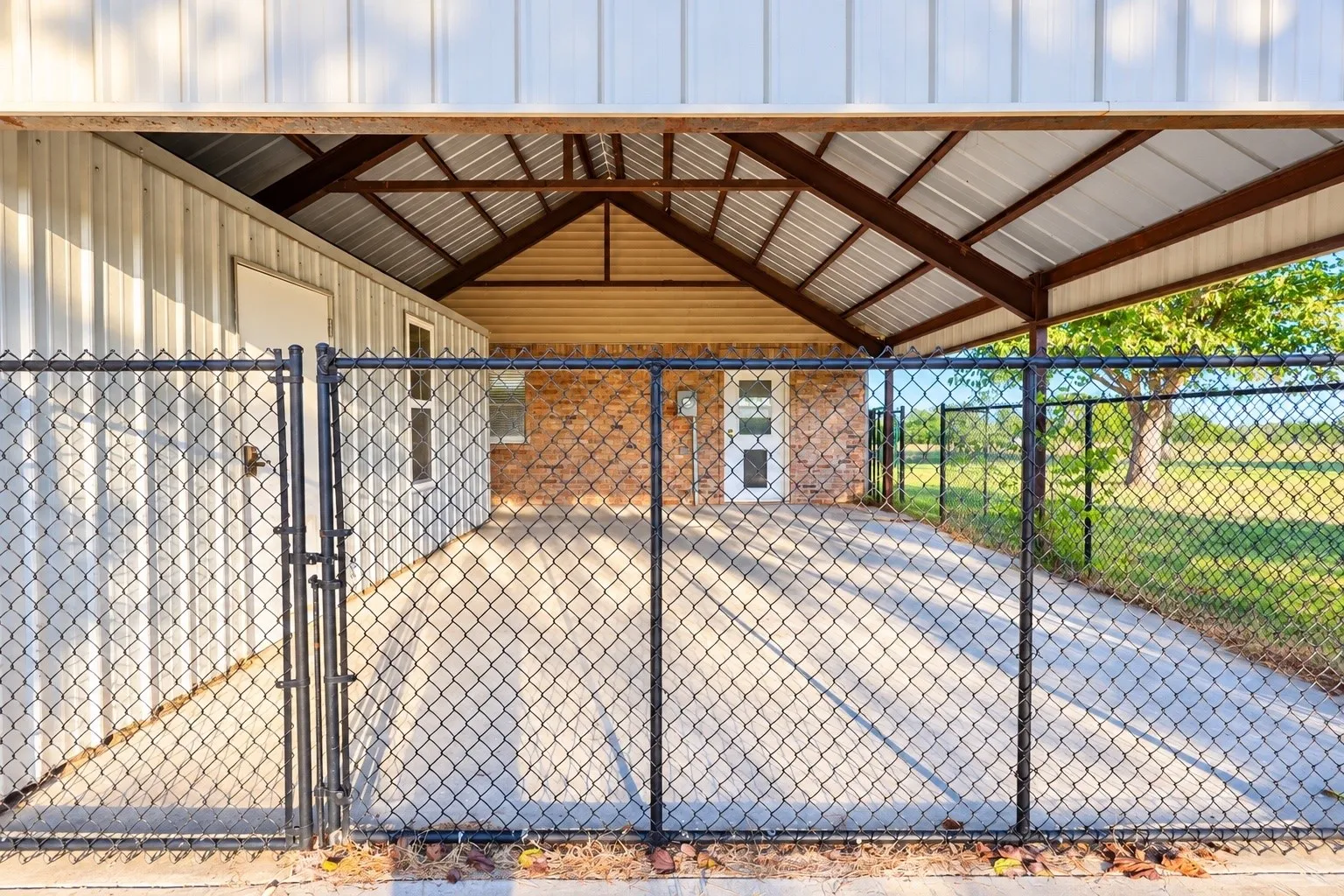 Fenced and covered back porch leads to laundry room.