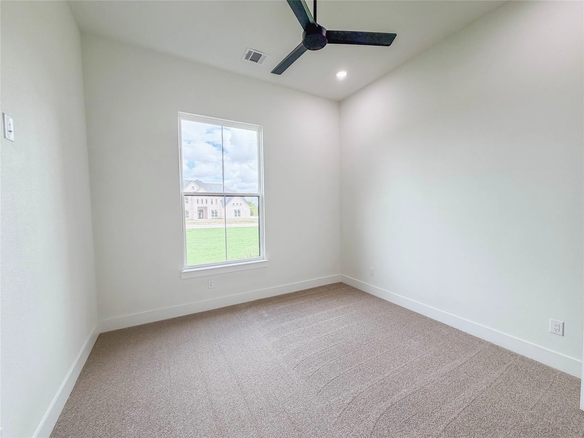 Plush carpeting, recessed ceiling lighting, ceiling fan, and a single window