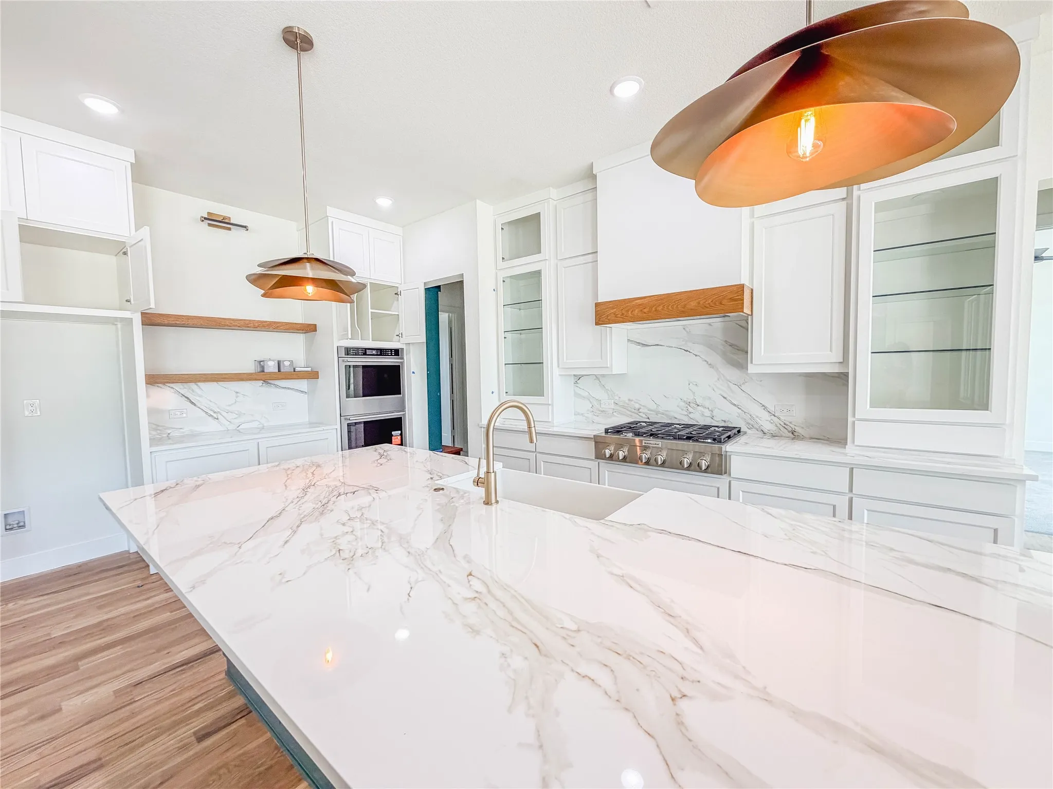 Expansive kitchen island with a smooth, white countertop featuring intricate veining