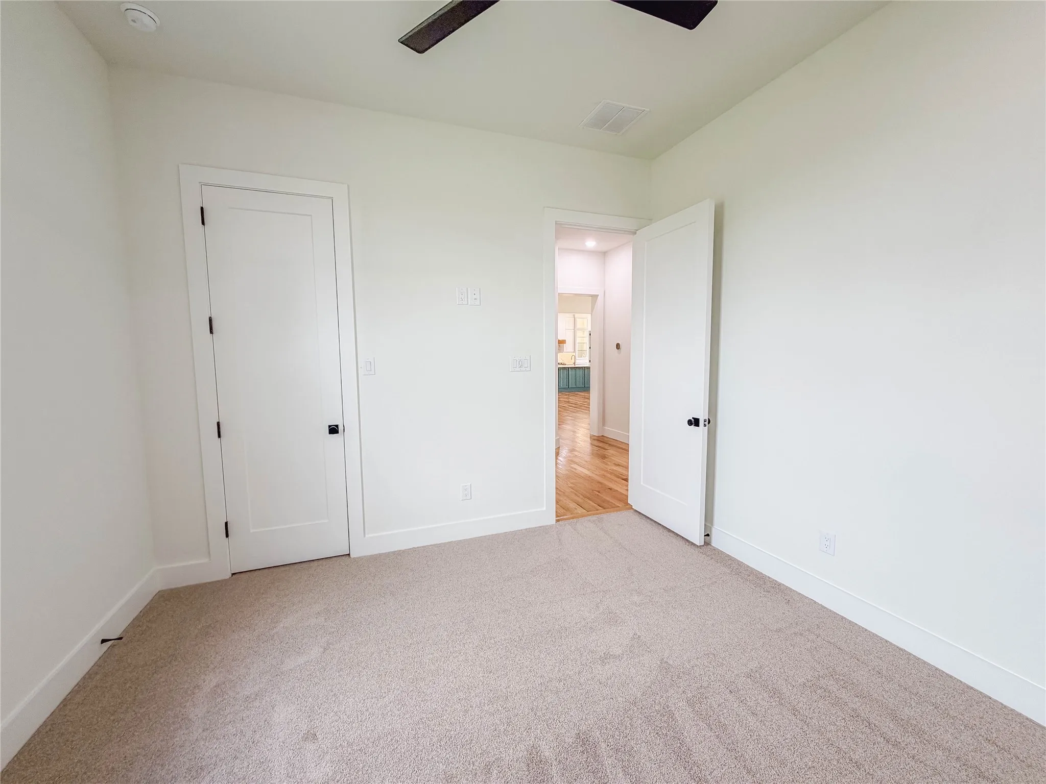 Neutral-toned carpet flooring, white walls, and white trim