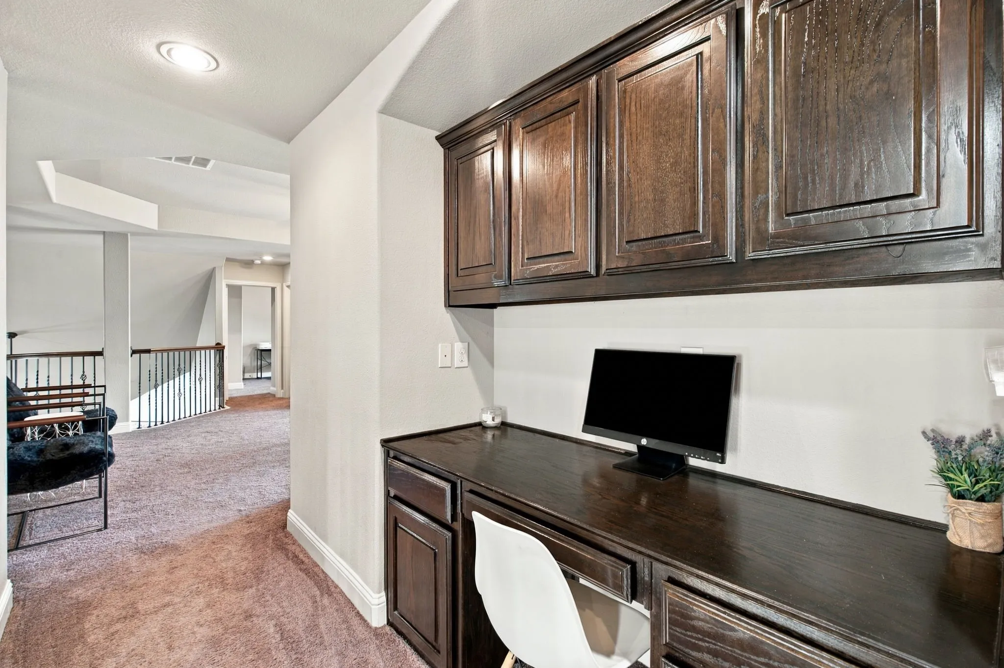 Convenient upstairs built-in workstation with rich wood cabinetry, generous counter space, and upper and lower storage, ideal for studying, working, or organizing household essentials.