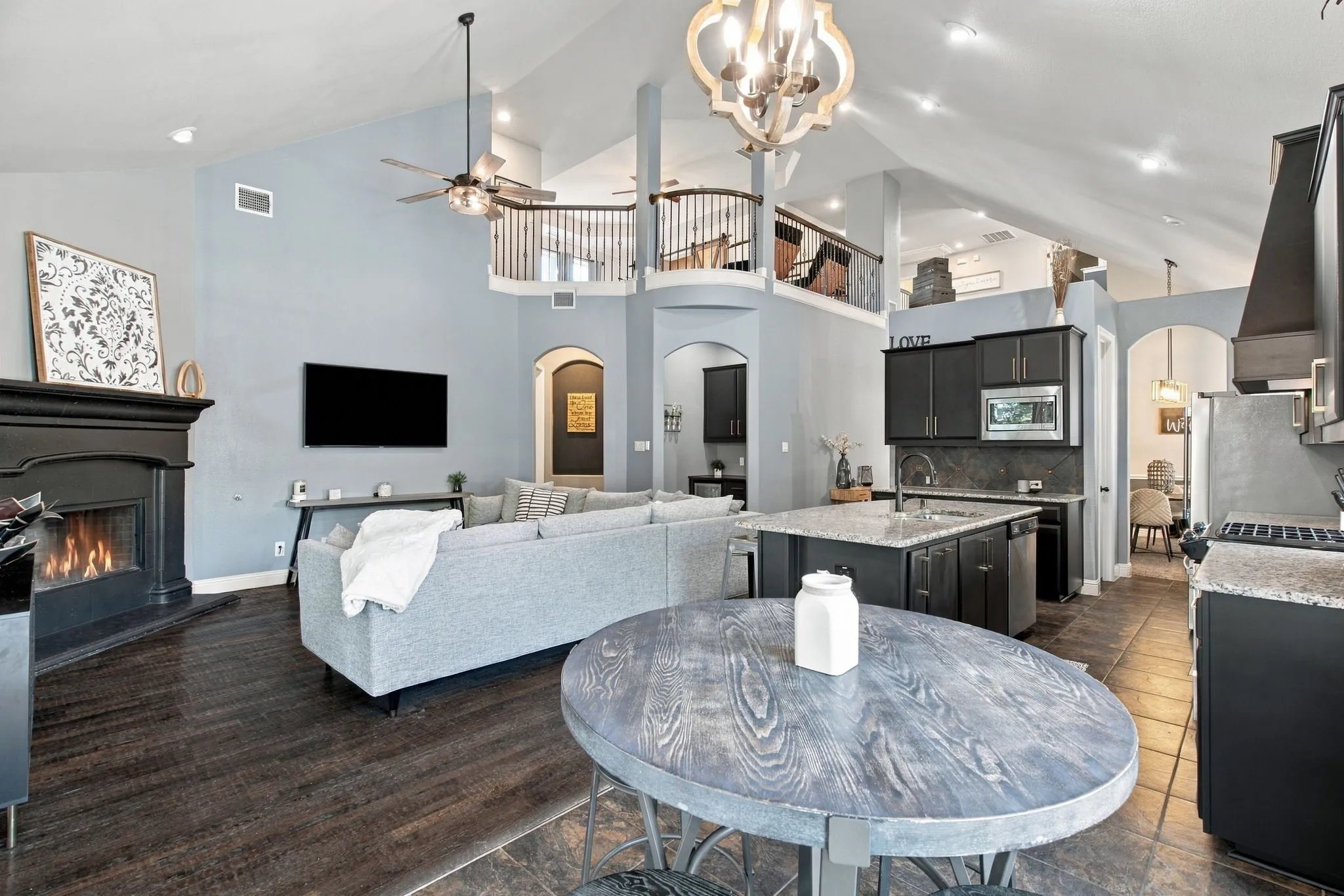 Impressive vaulted ceilings, an upstairs overlook, and a seamless connection between the living room, kitchen, and casual dining area create an open, inviting layout.