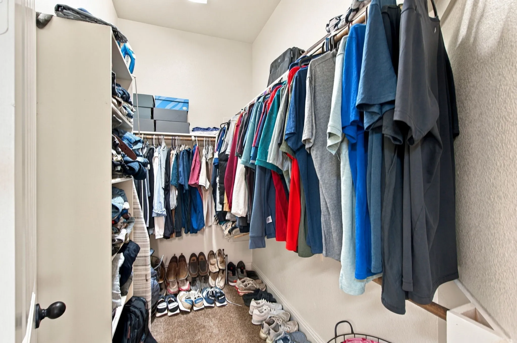 Additional primary walk-in closet offering generous hanging space, built-in shelving, and convenient storage for shoes, folded clothing, and accessories.