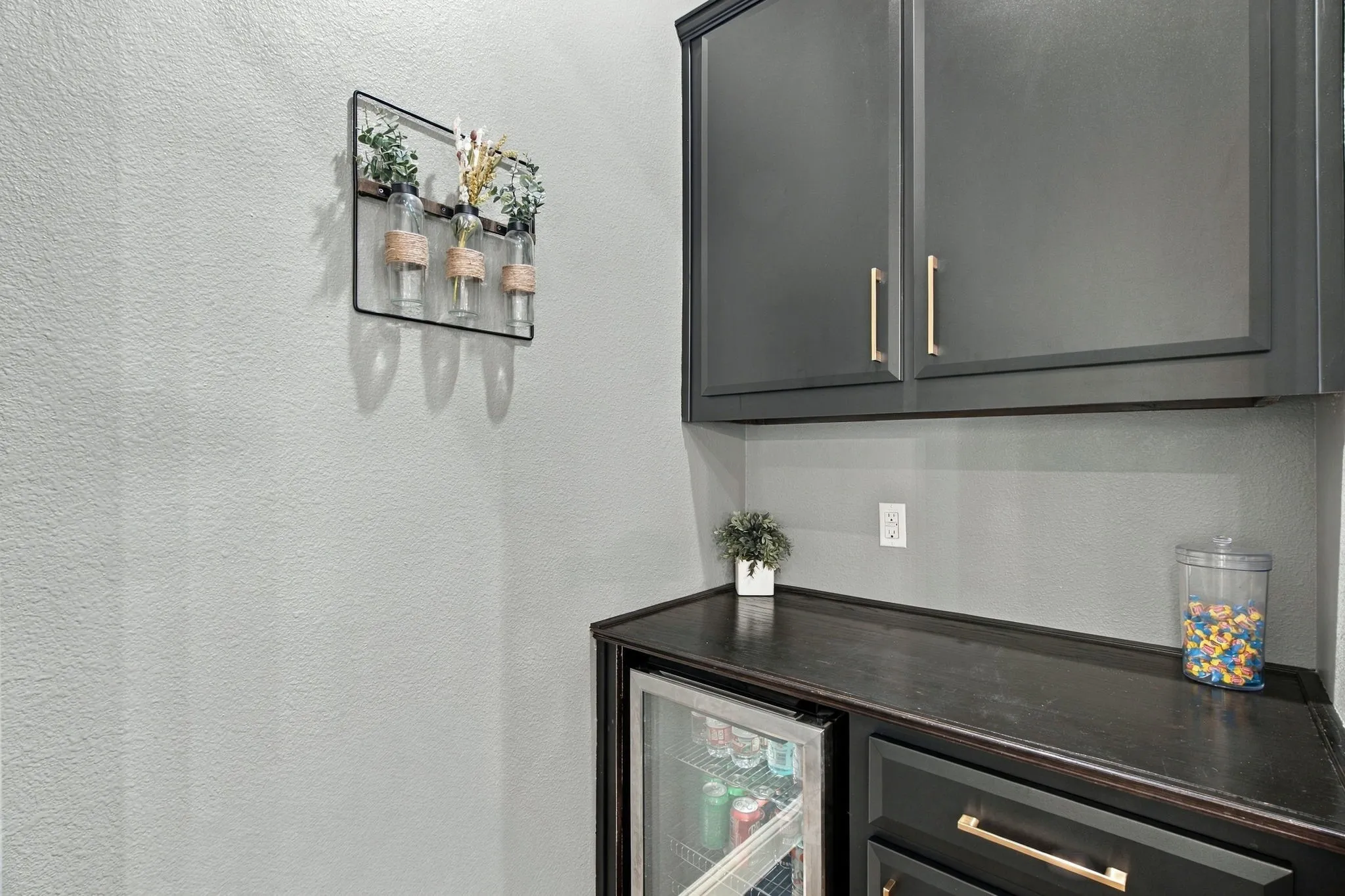 Convenient built-in cabinetry with upper storage, countertop space, drawers, and an undercounter beverage refrigerator.