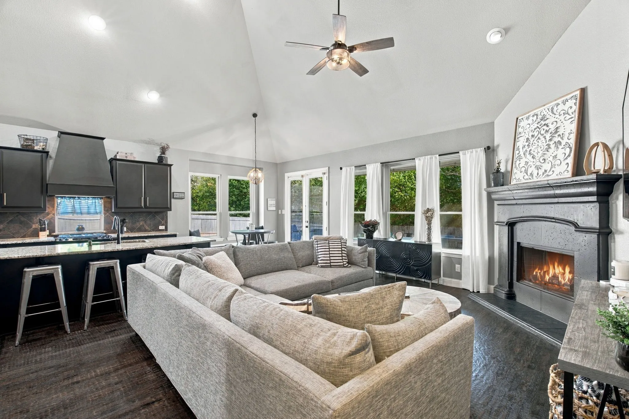 Large windows overlooking the backyard fill this inviting space with natural light, while the fireplace and open connection to the kitchen make it ideal for everyday living and entertaining.