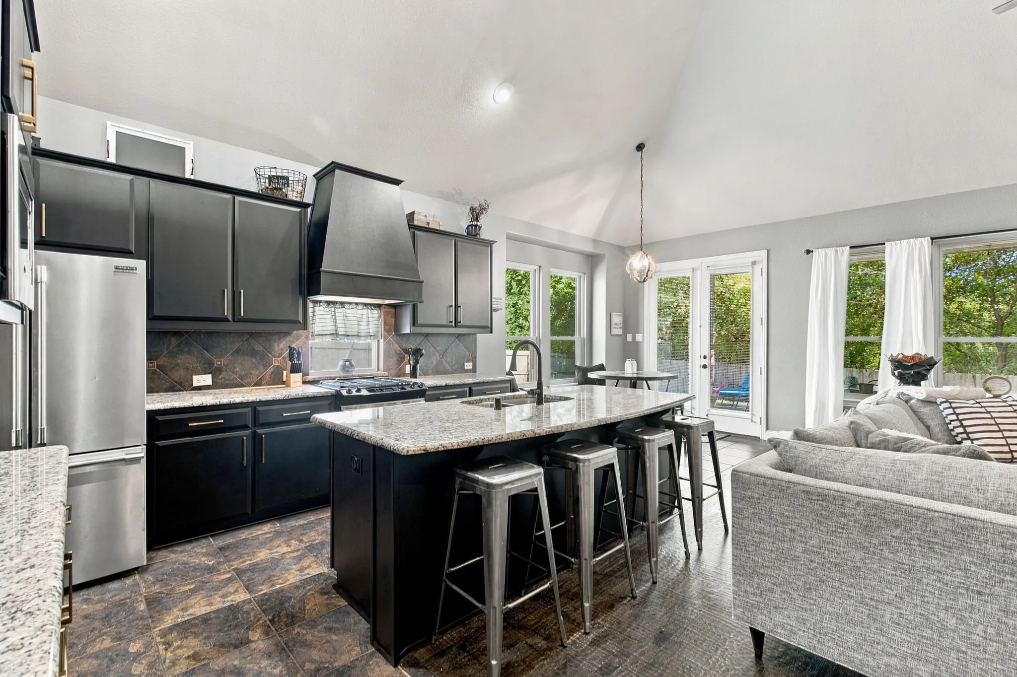 Brand new rich dark cabinetry, granite countertops, stainless steel appliances, a decorative tile backsplash, and generous island seating combine style with everyday functionality.