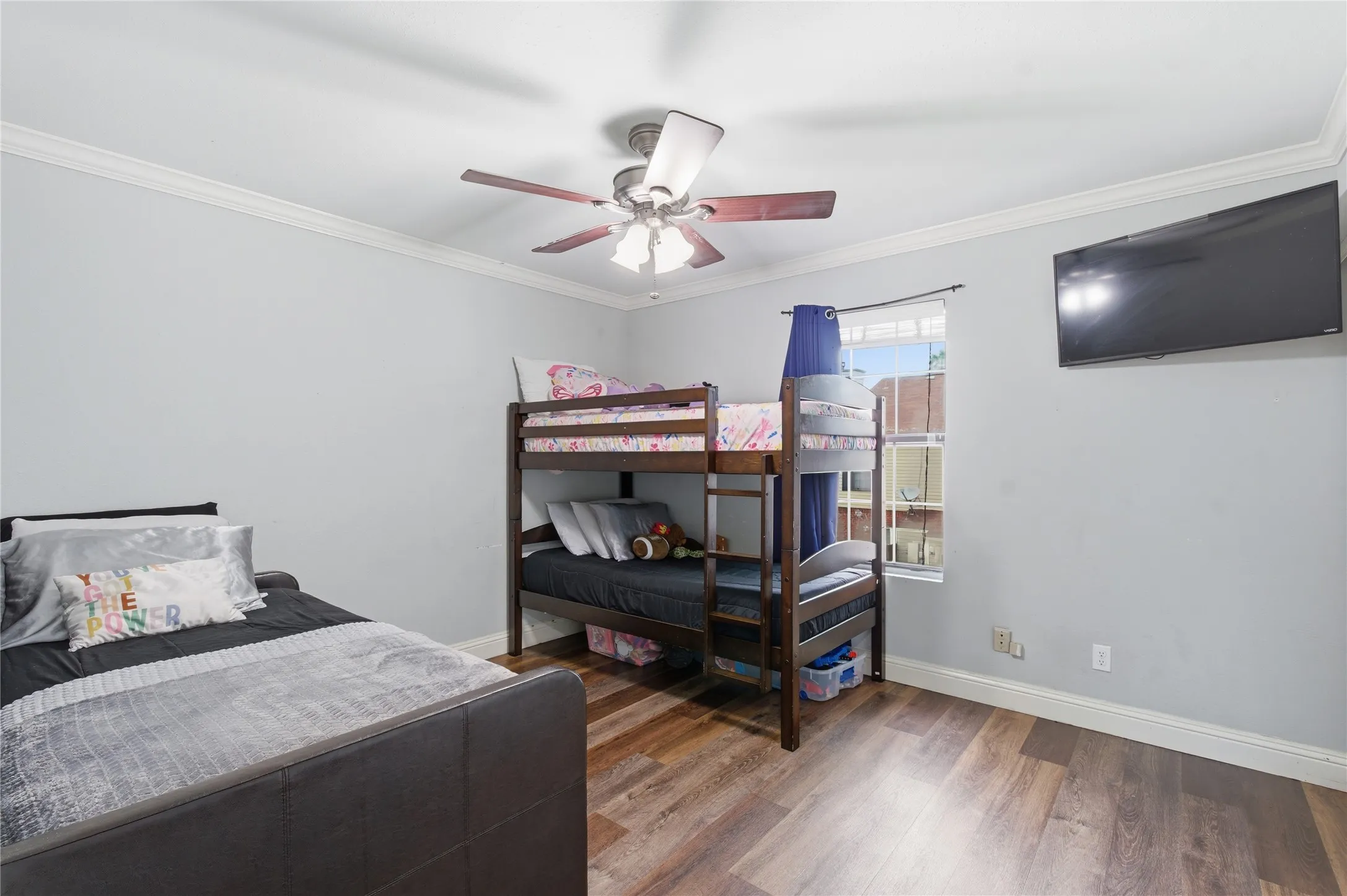 Wood-finish flooring, crown molding, and a ceiling fan with integrated lighting