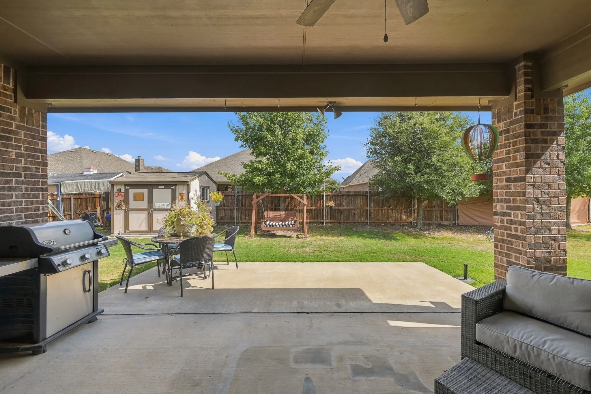 Covered patio for comfy outdoor gatherings. Notice the shed for additional storage.
