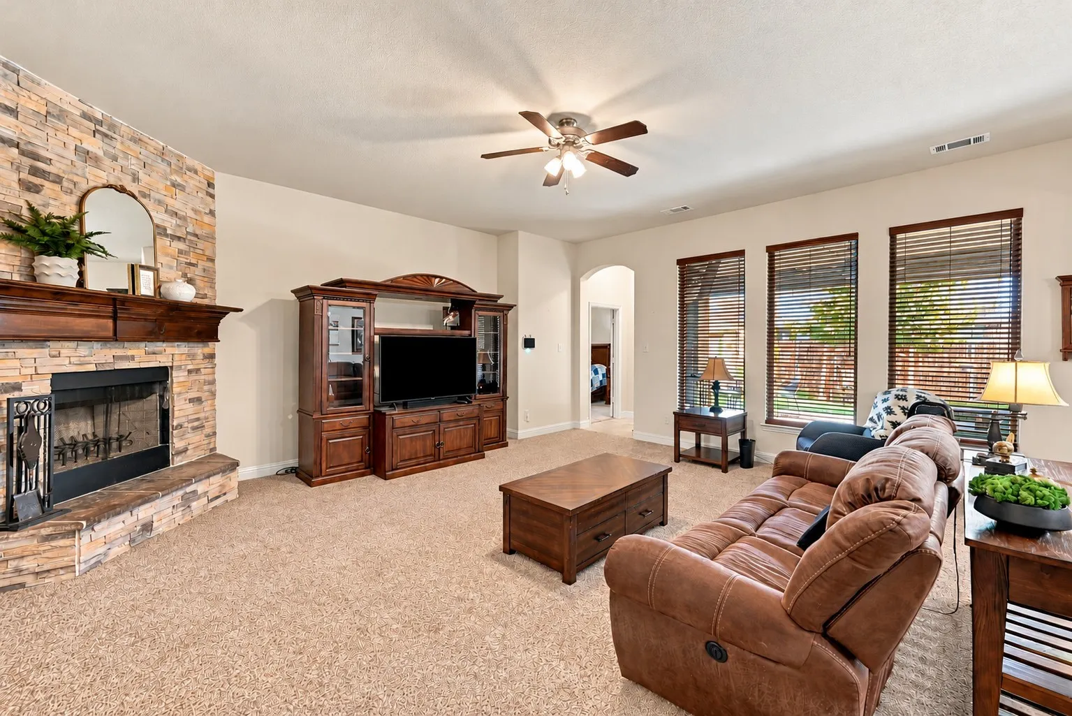 Large living area with woodburning fireplace and tons of natural light.