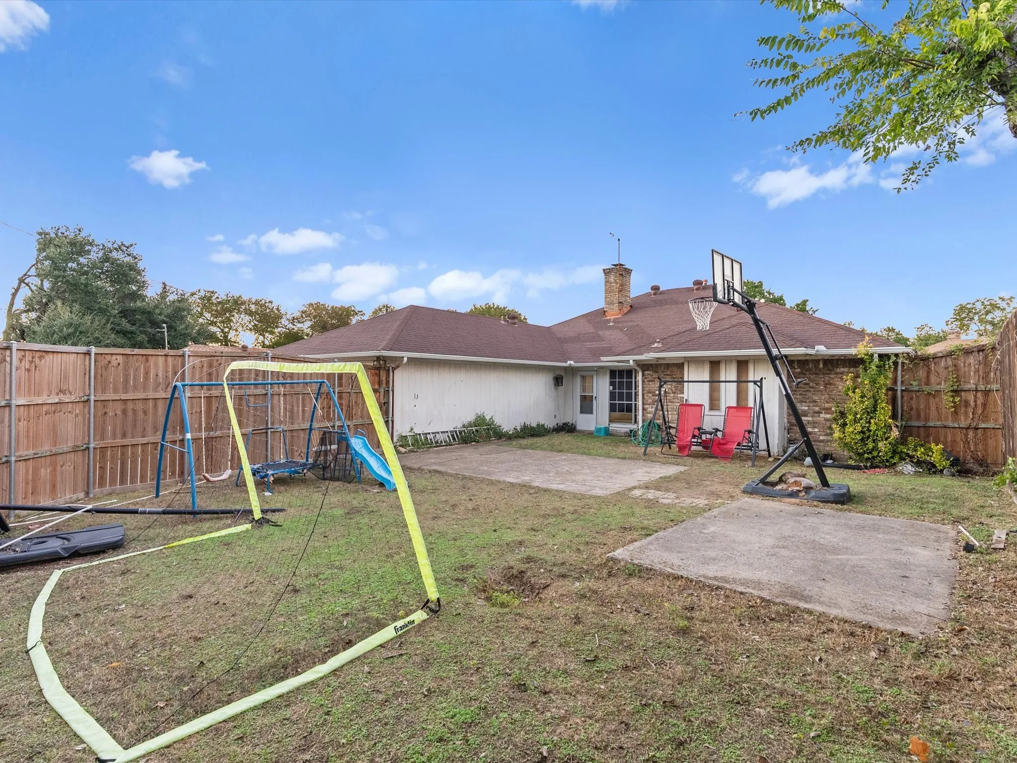 Fenced backyard with concrete patio areas