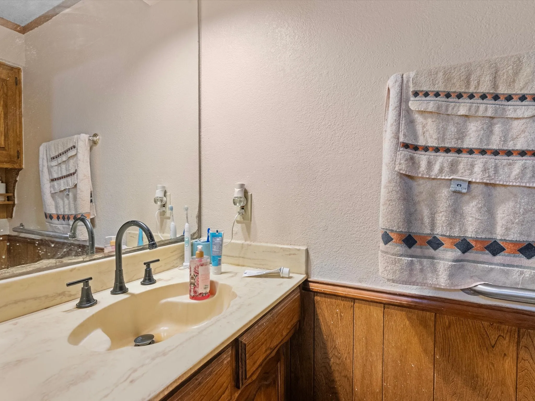 Half bath. Vanity with an integrated sink, dark bronze-finish faucet, and coordinating dark bronze-finish knob handles