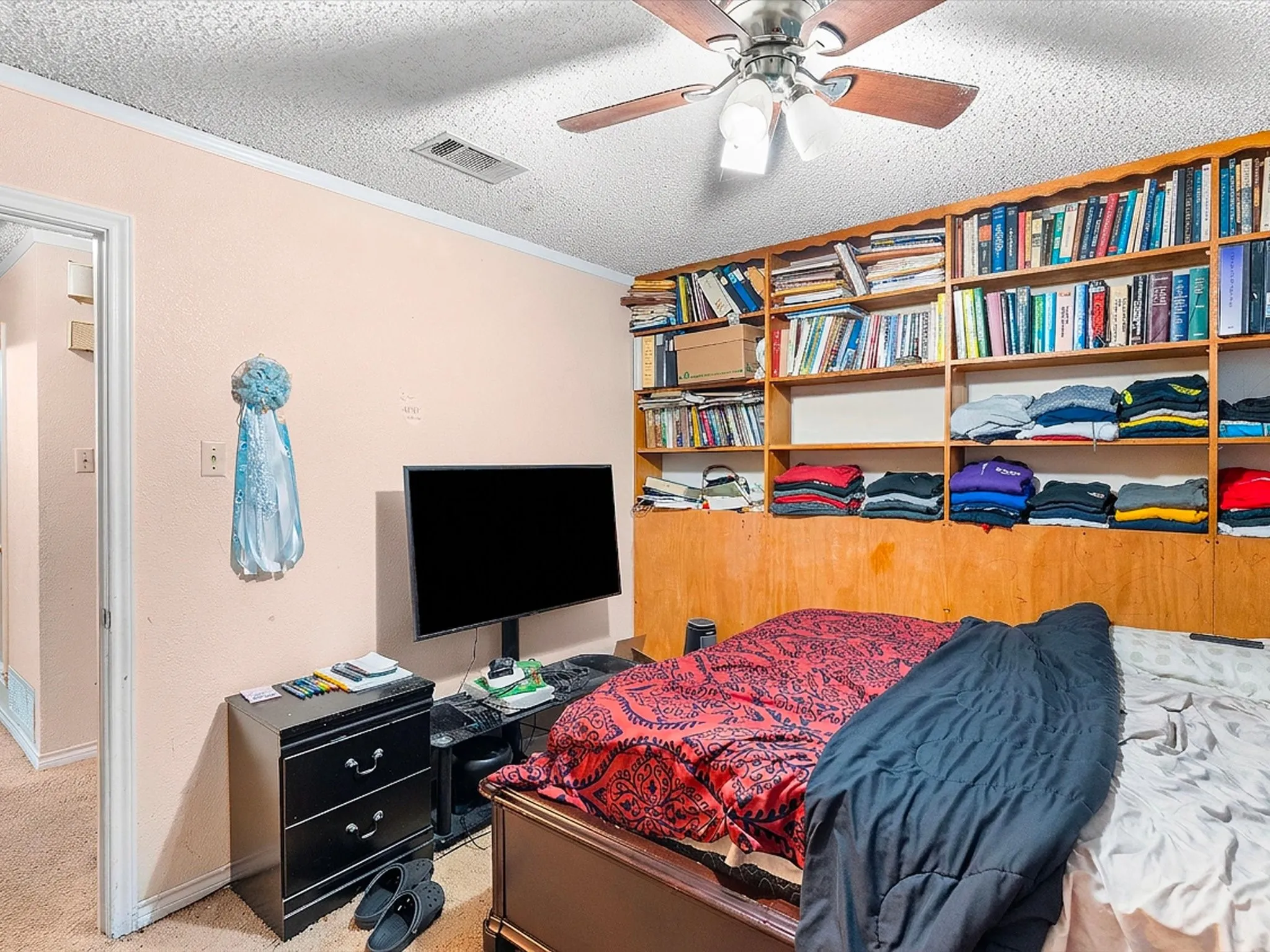 Integrated wall-to-wall shelving with wood paneling, ceiling fan with light fixture