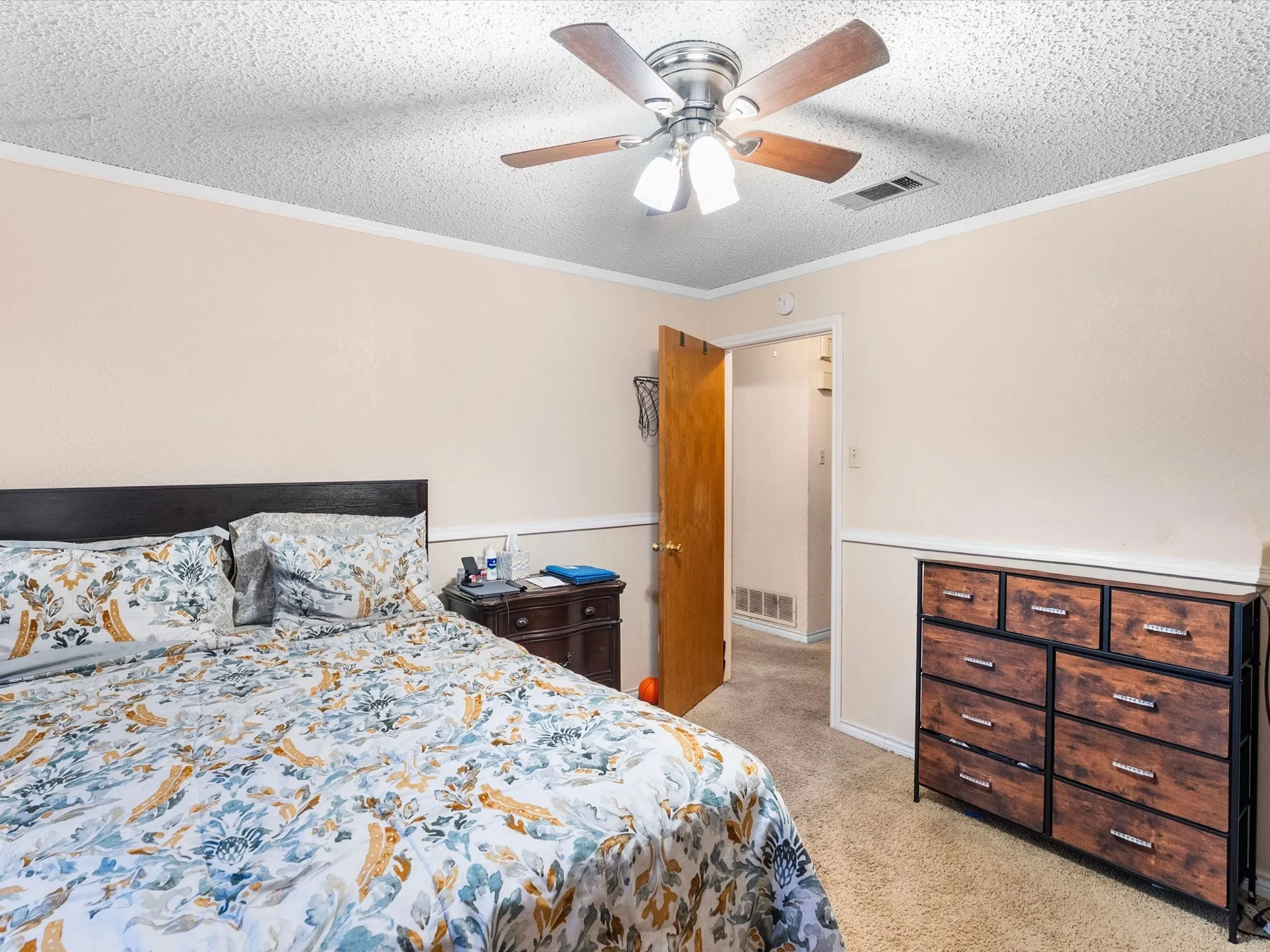 Neutral-toned walls with chair rail molding and carpeted flooring