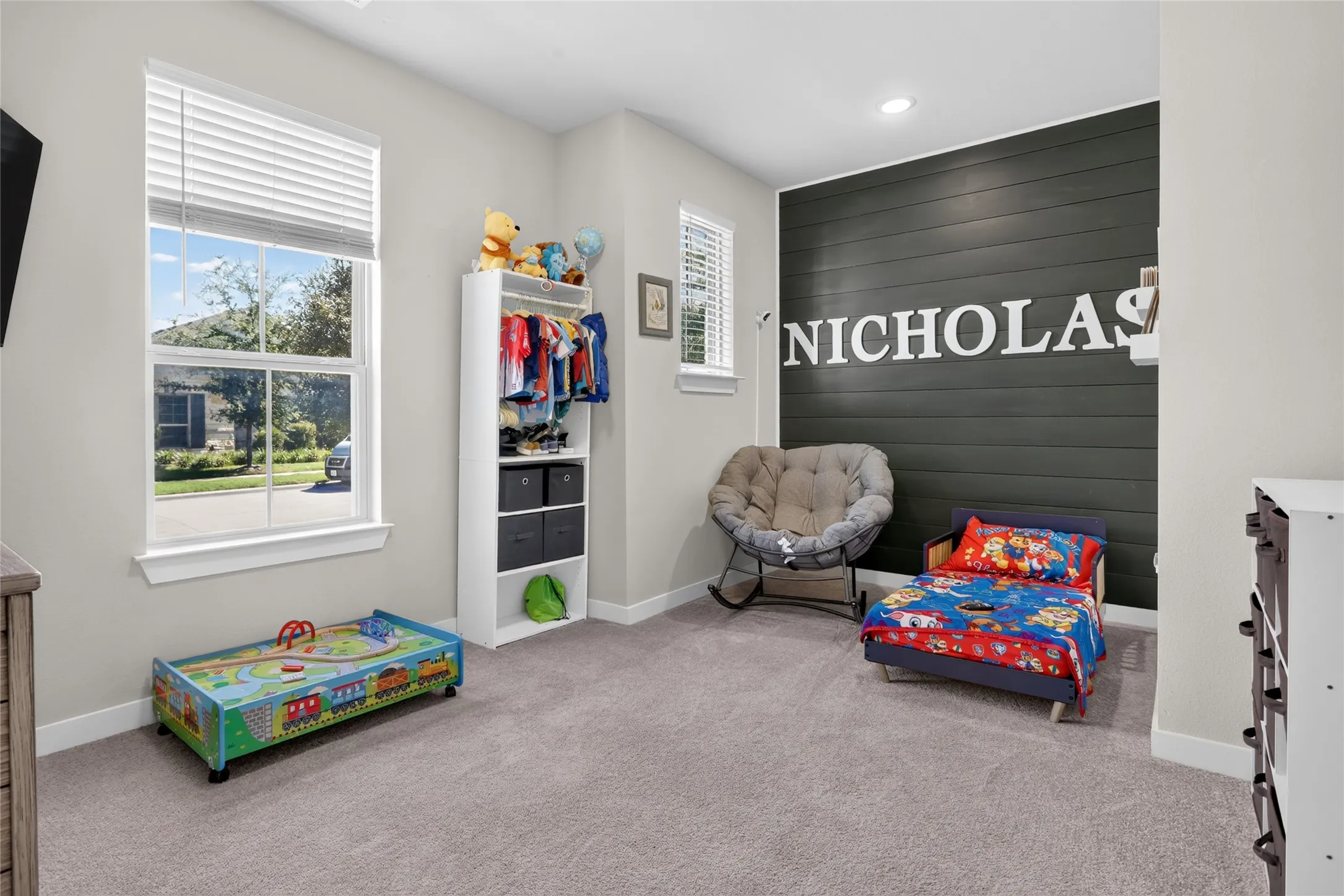 Plush carpet flooring, recessed lighting, and a dark accent wall with shiplap detailing