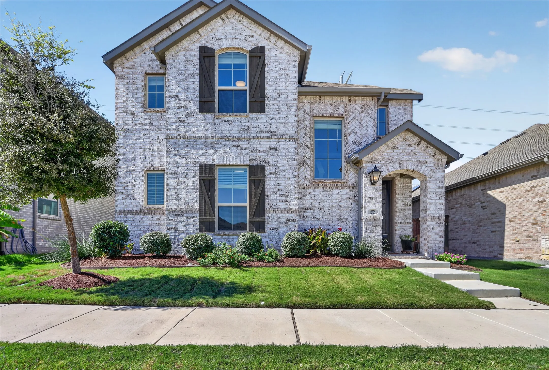 Stone facade with dark shutters and window trim