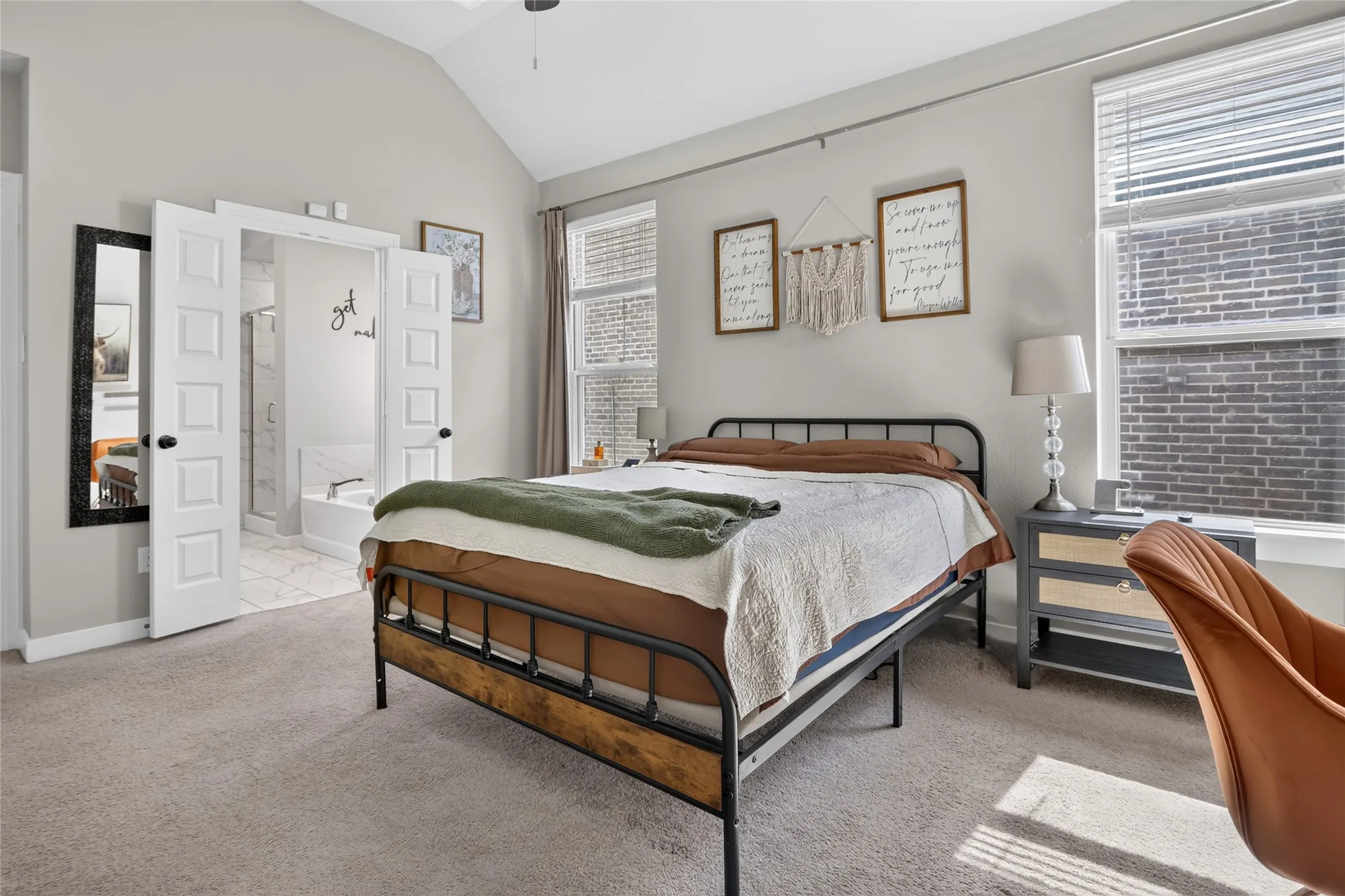 Vaulted ceiling, carpet flooring, window with blinds, double doors, and a ceiling fan