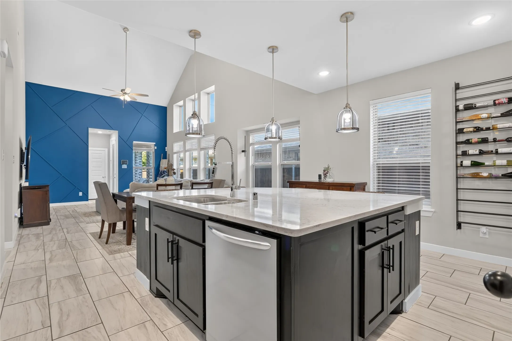 Kitchen island with integrated sink, stainless steel appliance, and pendant lighting