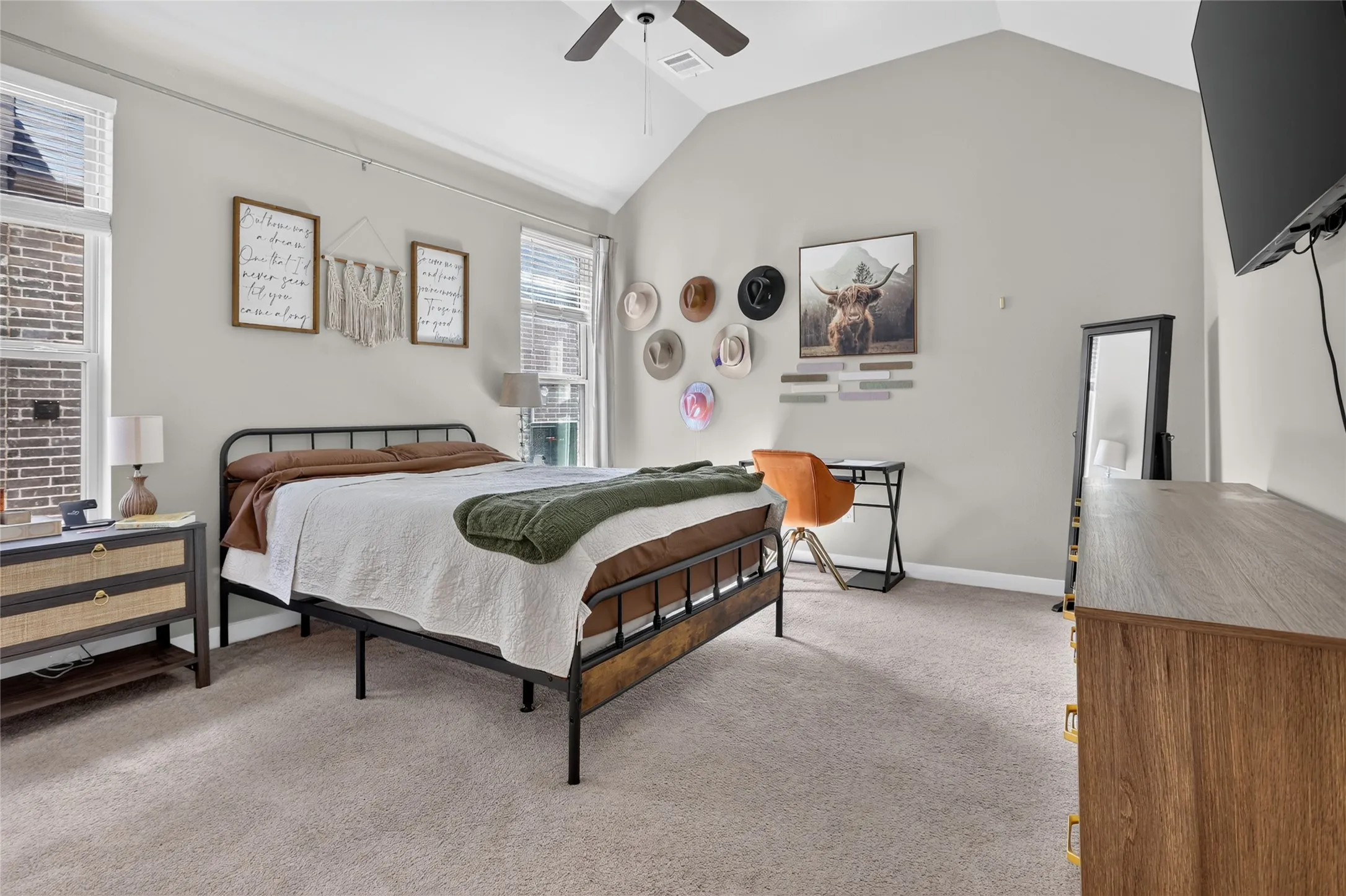 Vaulted ceiling with ceiling fan, light gray wall paint, and carpeted flooring