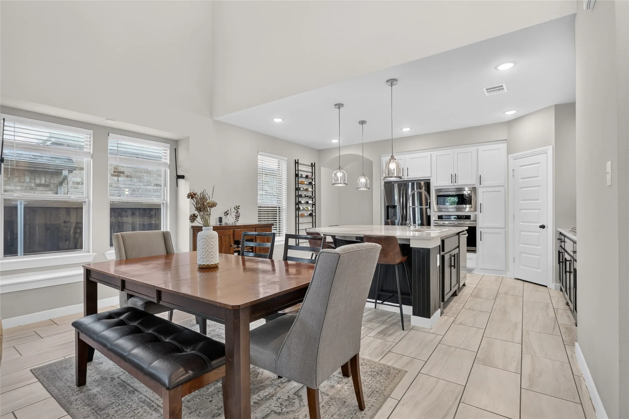 Combined kitchen and dining area featuring vaulted ceilings and recessed lighting