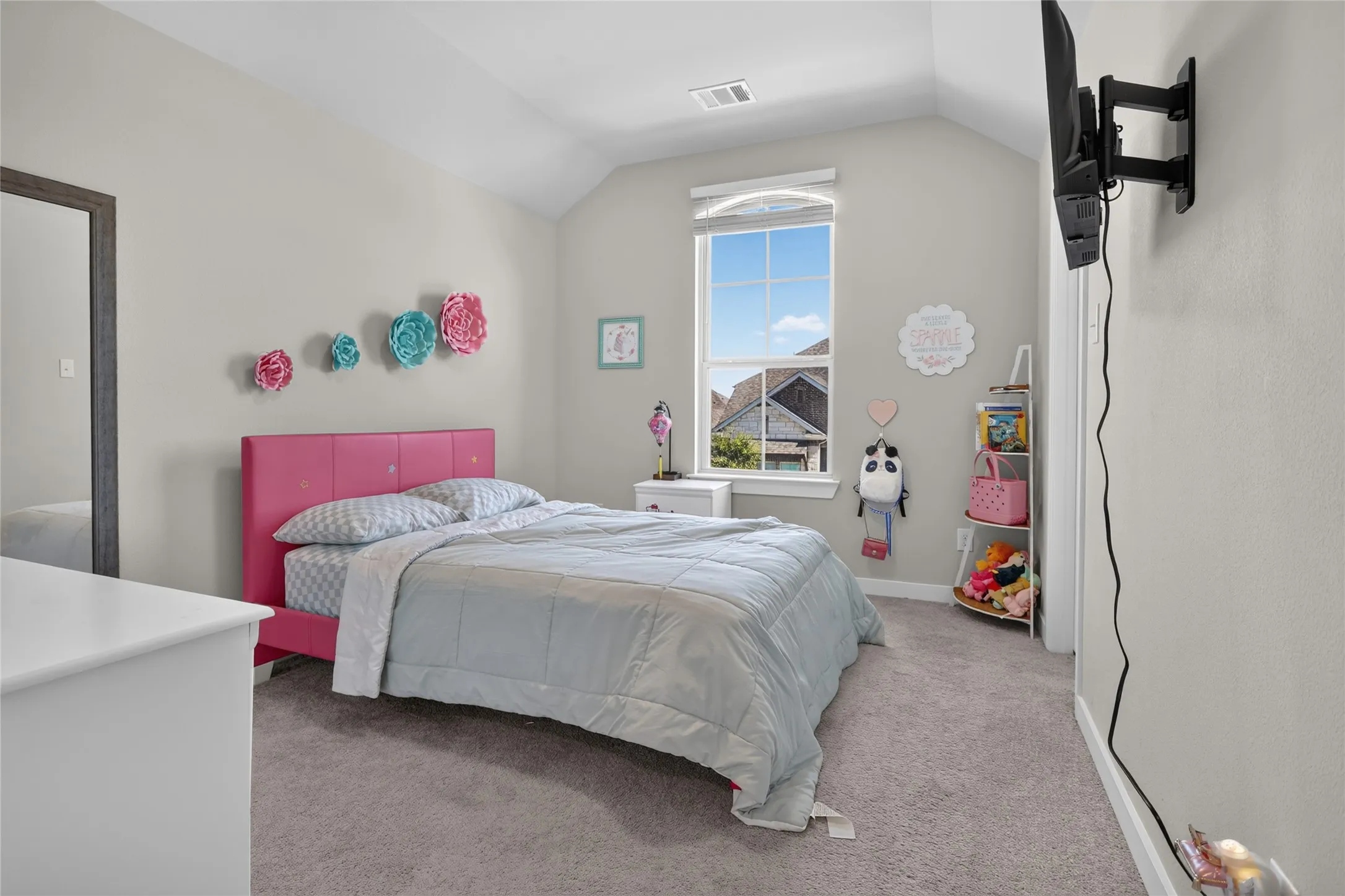 Carpeted flooring, vaulted ceiling, and a large window with natural light