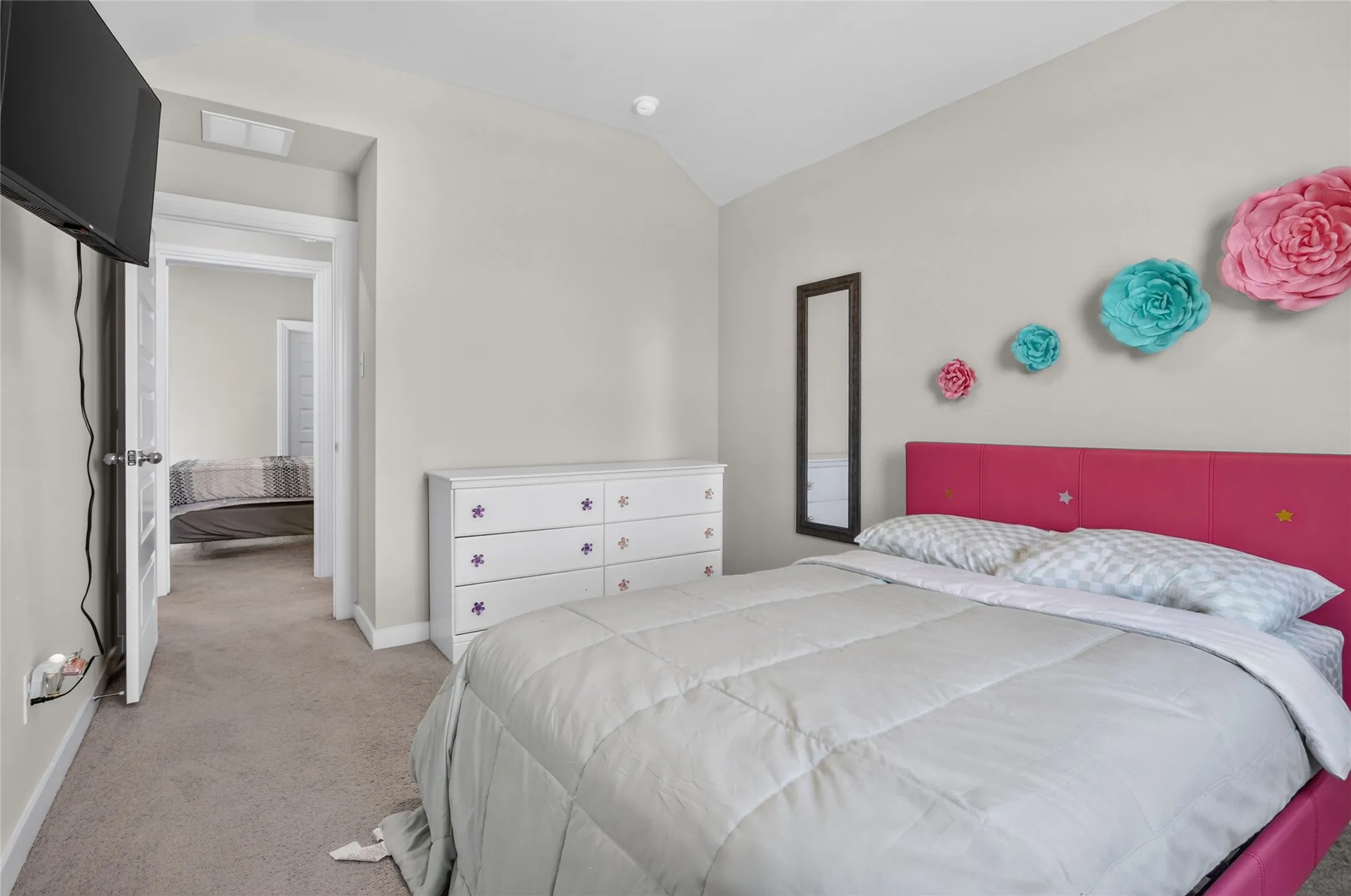Carpeted flooring, vaulted ceiling, white interior doors, and a built-in wall niche