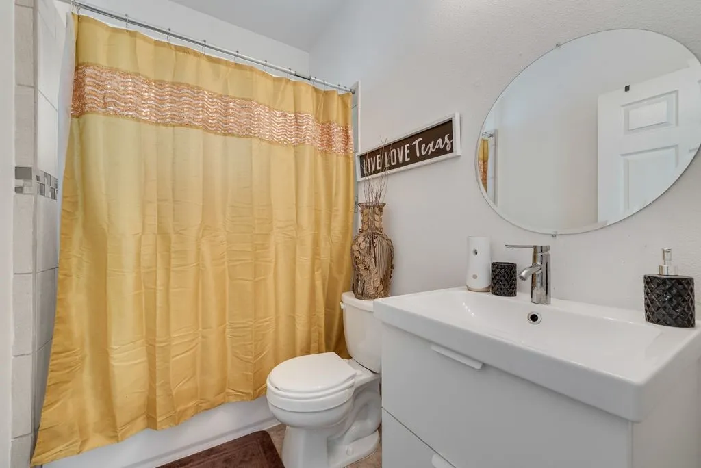 White wall-mounted vanity with integrated sink, chrome faucet, and oval mirror
