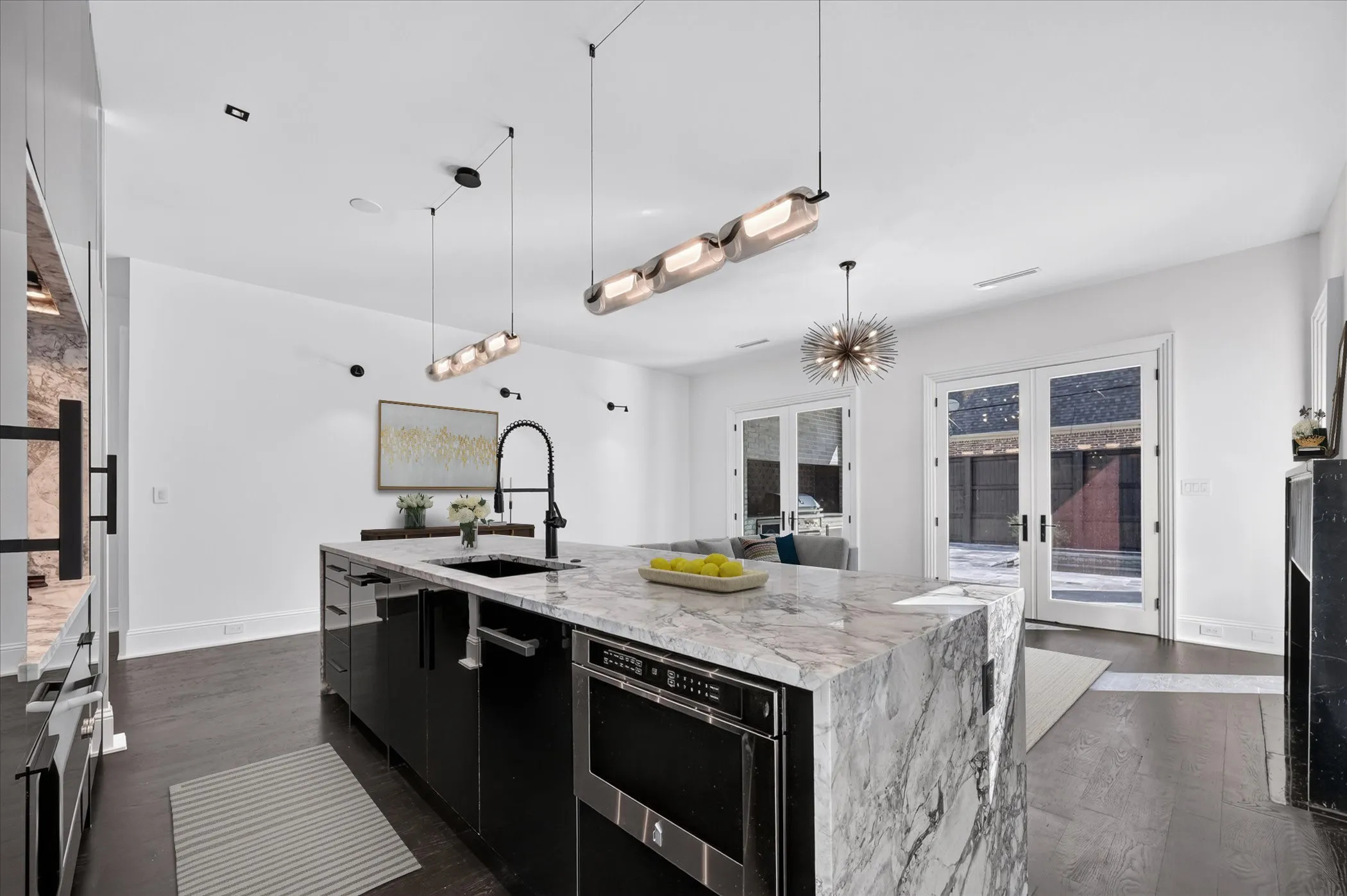 Waterfall island with integrated sink and dishwasher, dark wood-finish flooring, white walls, recessed ceiling lighting, and double glass French doors