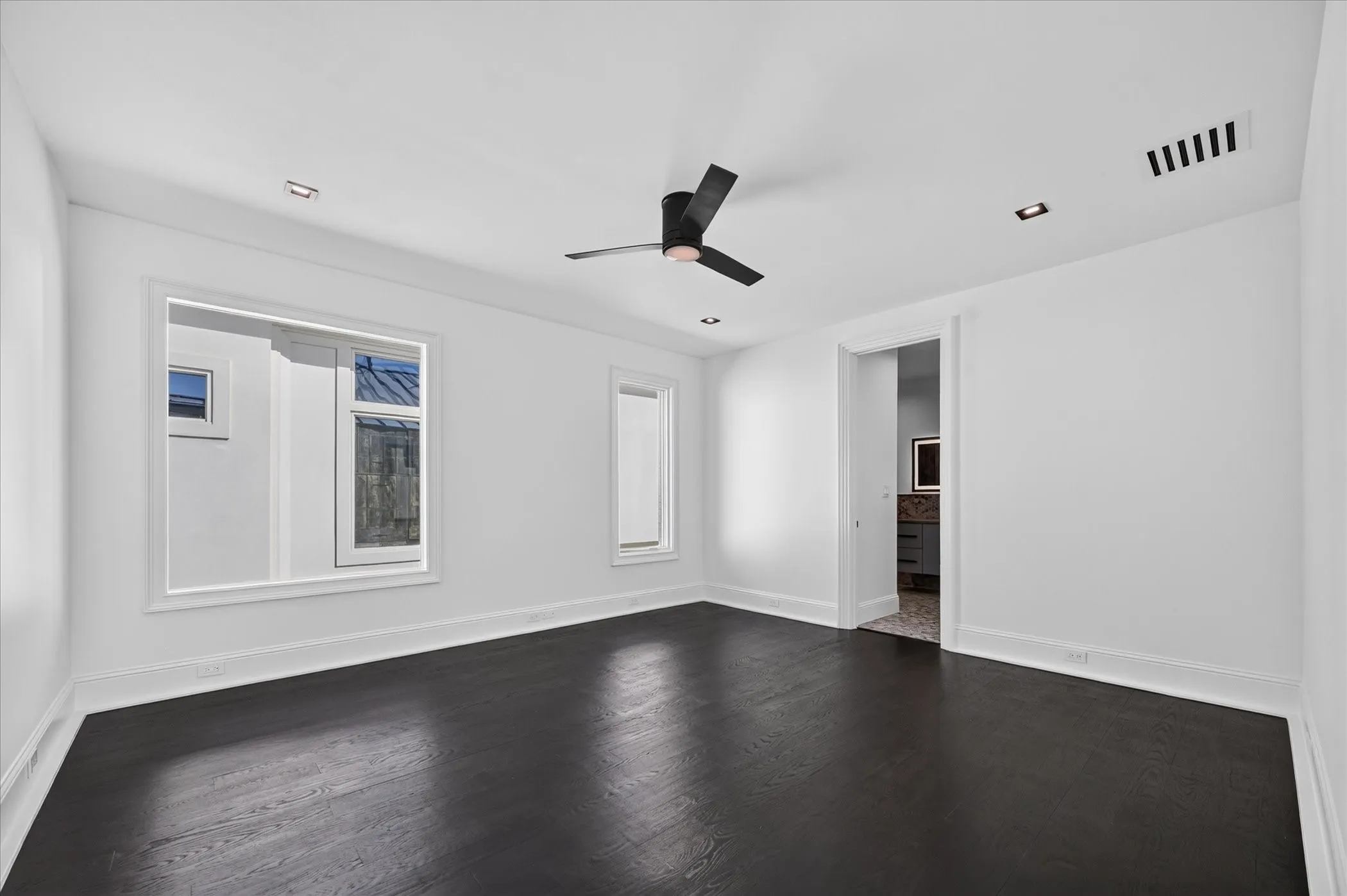 Dark wood-finish flooring with white walls