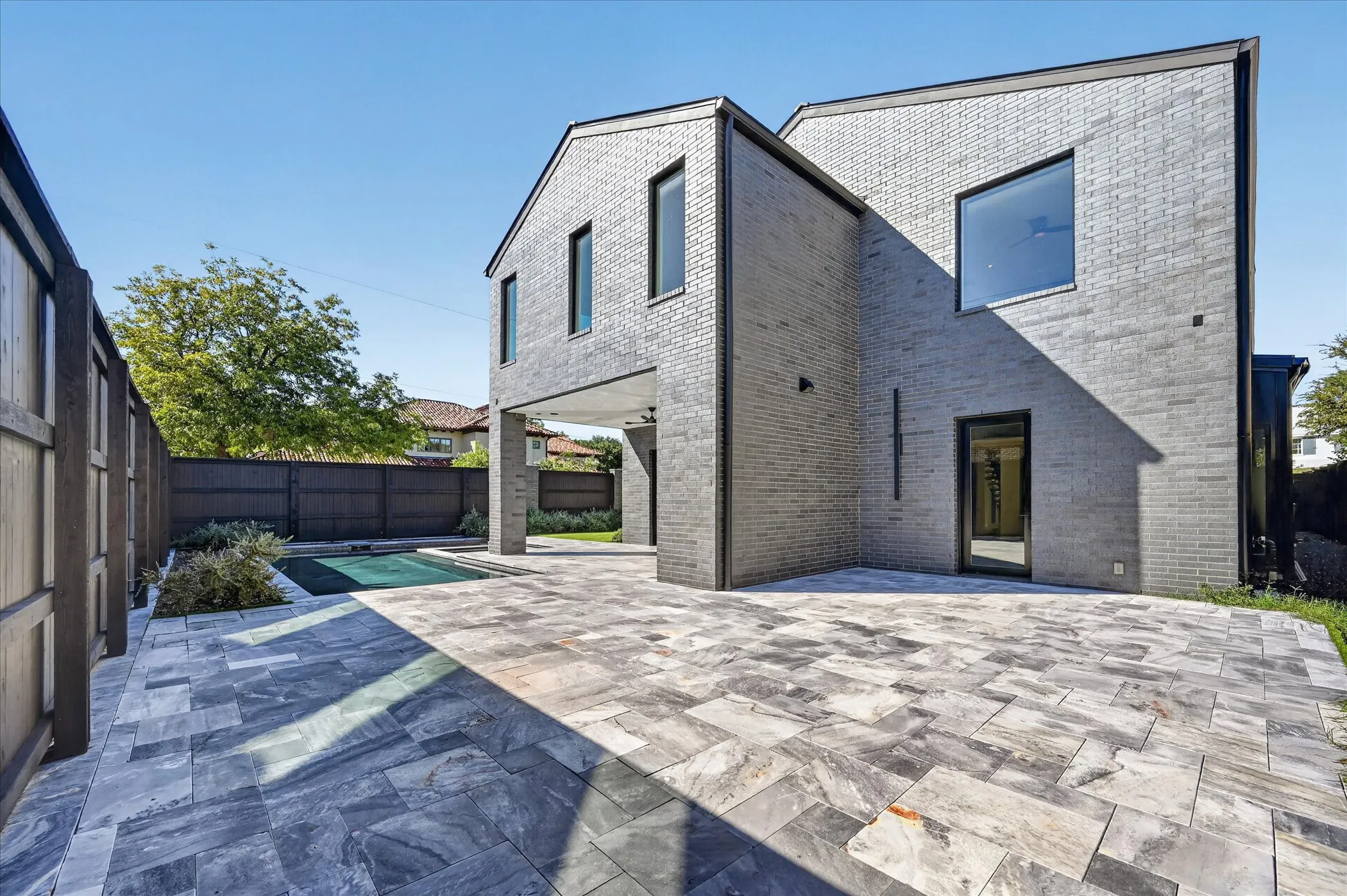 Exterior featuring gray brick construction and dark frame windows