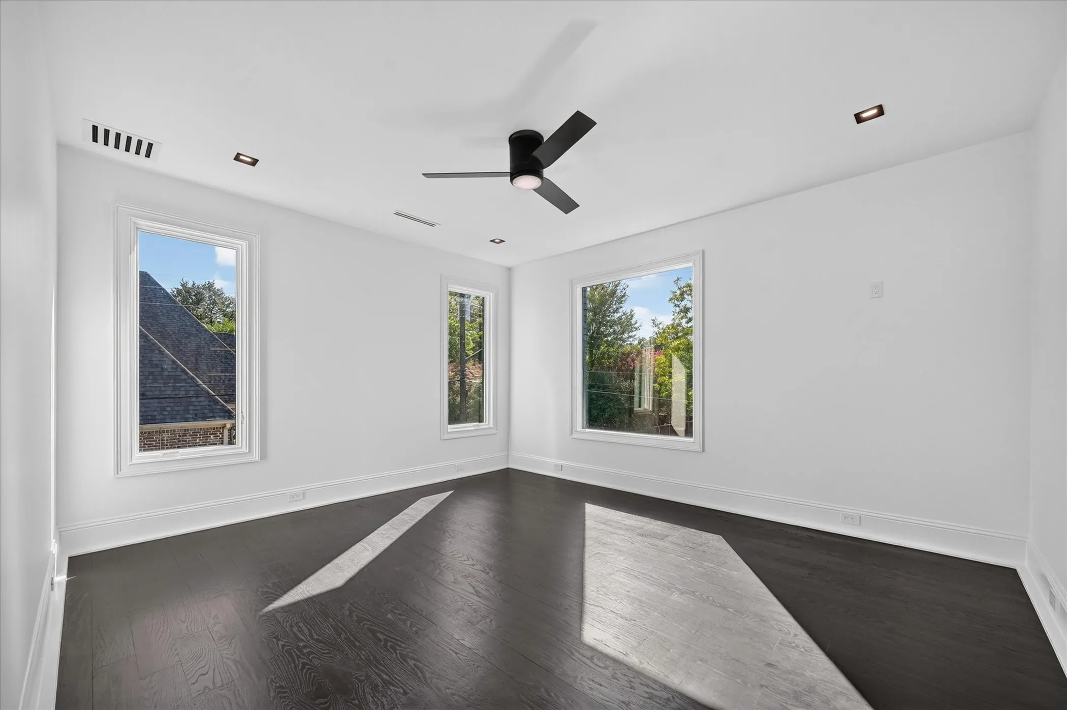 Dark wood-finish flooring with white baseboards