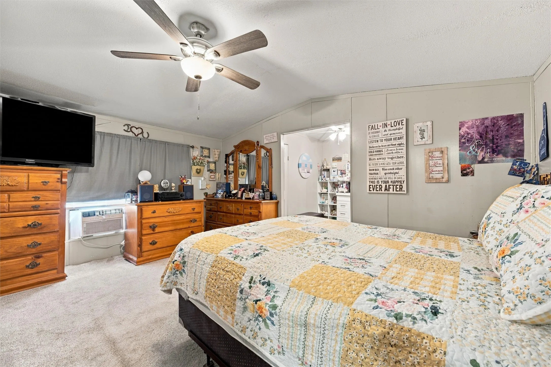 Ceiling fan with integrated lighting, carpeted flooring, and paneled walls