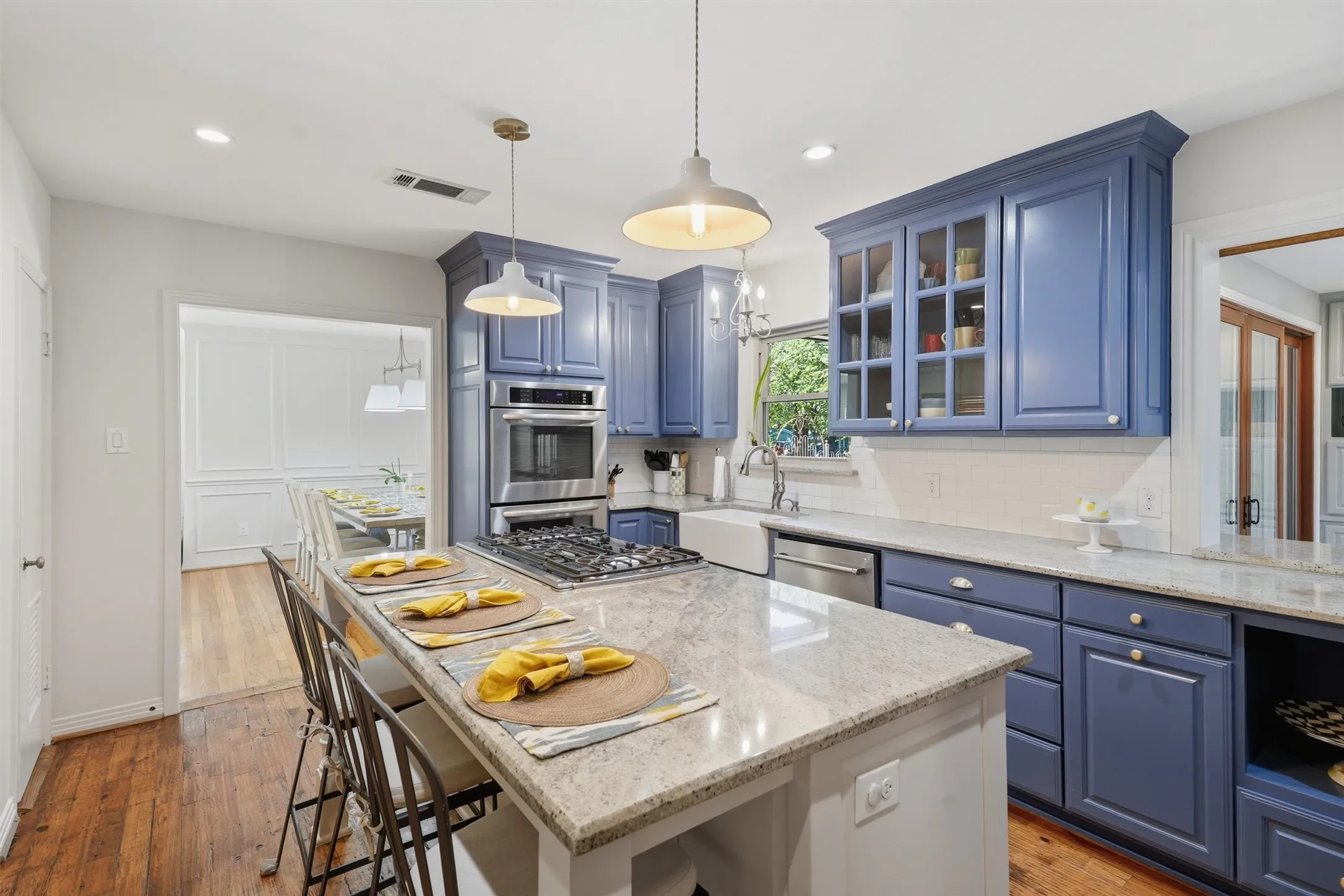 Stylish chef kitchen featuring custom blue cabinetry and a center island with seating