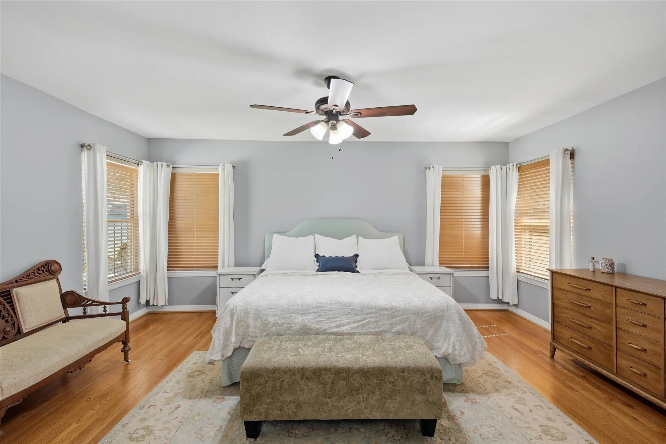 Spacious primary bedroom featuring Symmetrical corner windows provide generous natural light. The primary bedroom also features double closets.