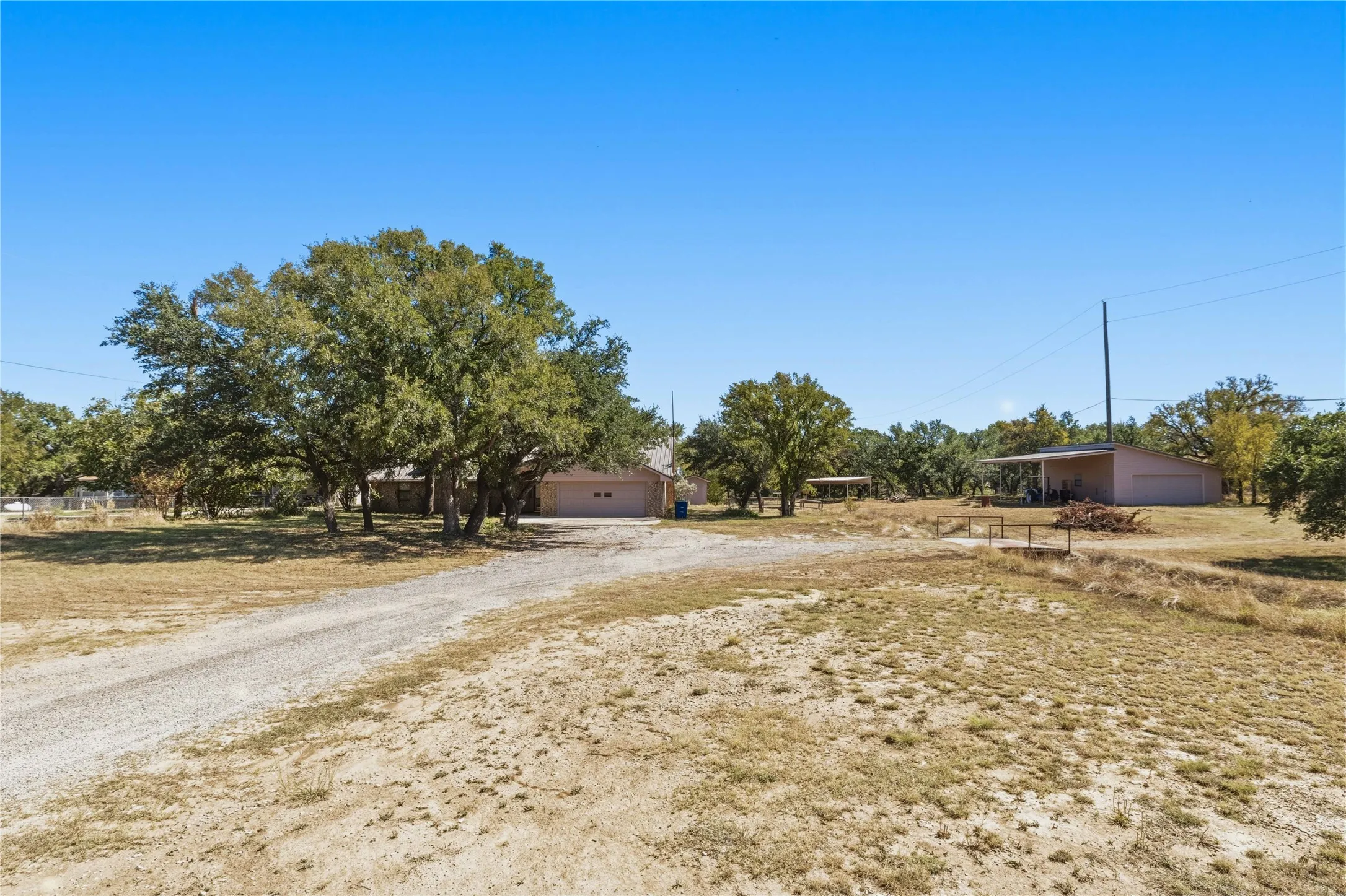 Full front of property view with home on the Left and over the bridge the shop on the right.
