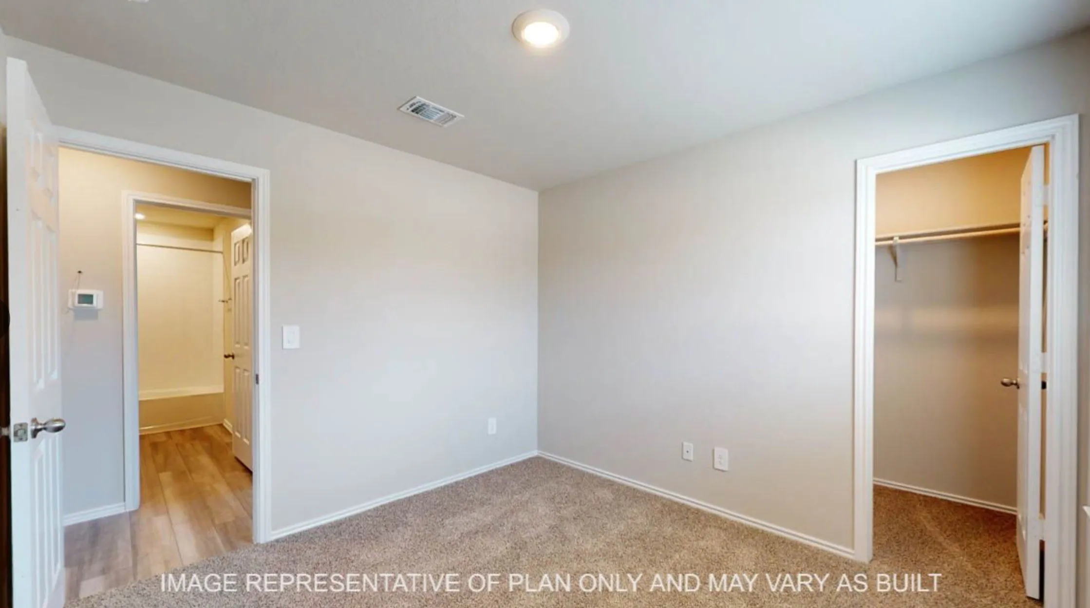 Neutral wall paint, recessed lighting, carpet flooring, and a built-in closet with shelving