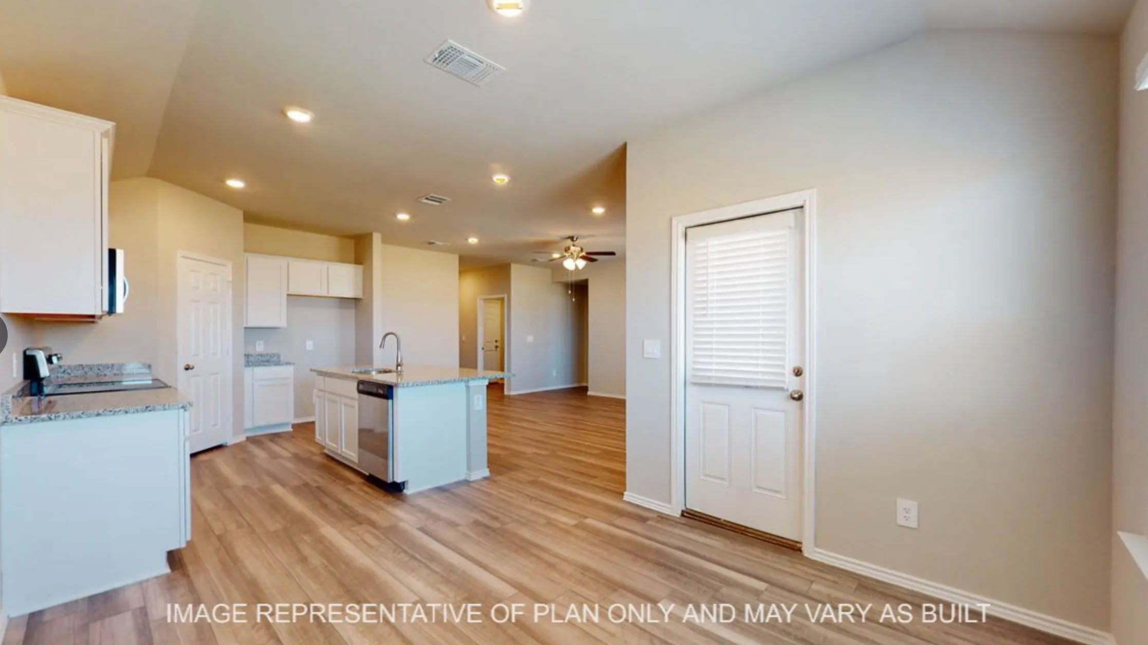 Open-concept interior featuring wood-finish flooring, recessed lighting, and a kitchen island with a stainless steel sink and appliances