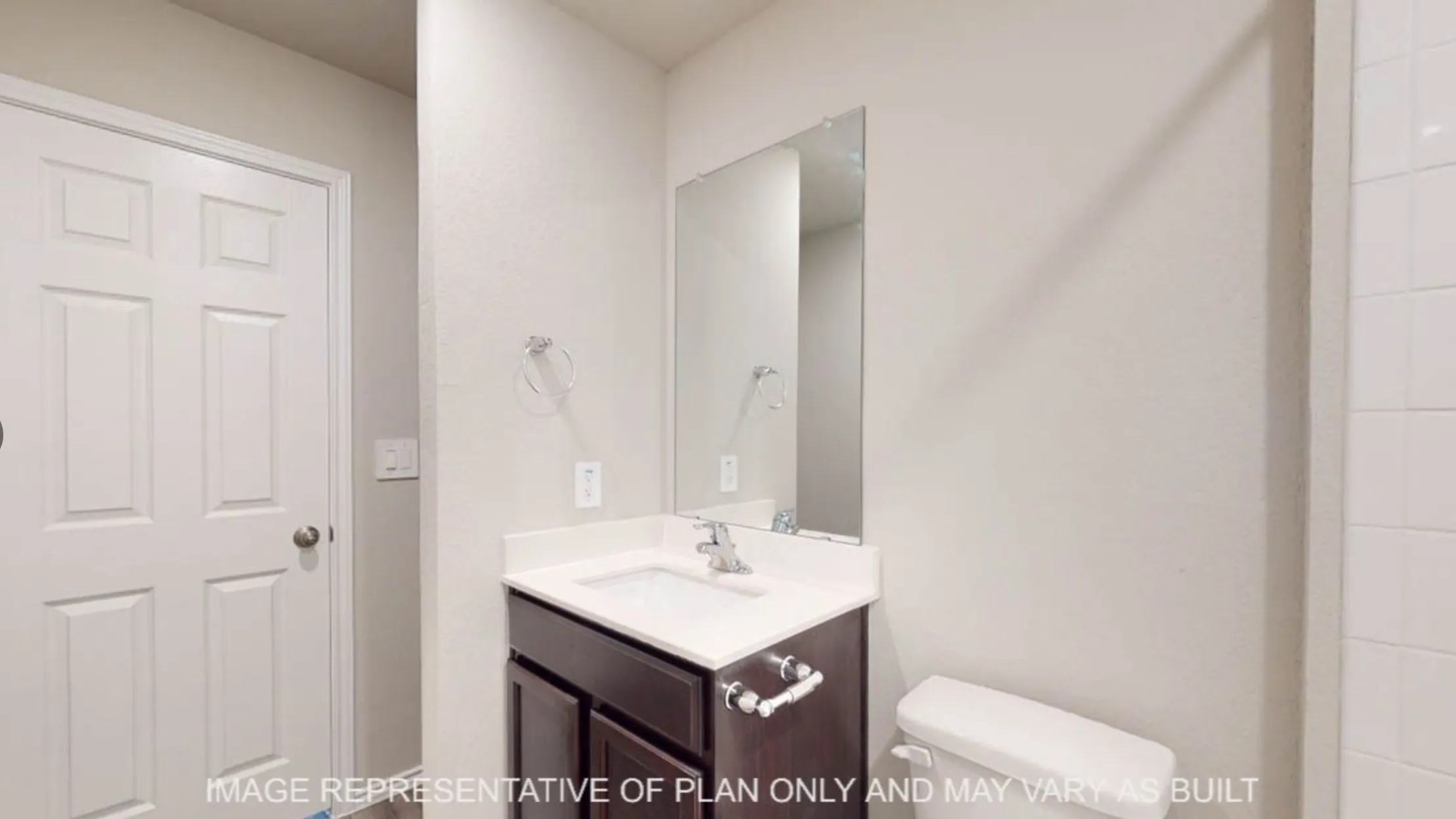 Vanity with dark wood-finish cabinetry, white countertop, and integrated sink