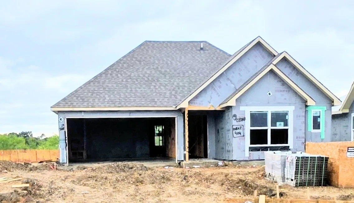 New construction residence featuring a composition shingle roof, attached two-car garage, and multiple windows