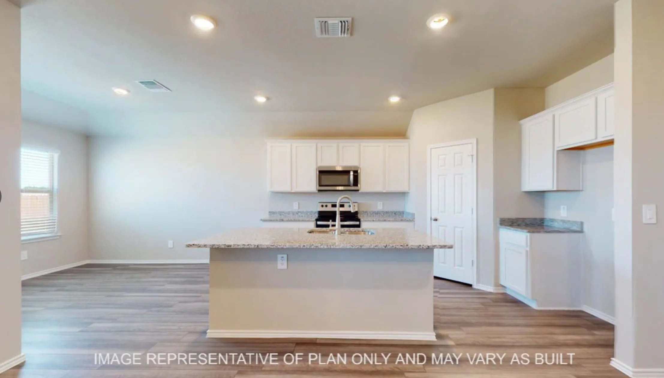 Open-concept kitchen with a central island, recessed lighting, stainless steel appliances, white cabinetry, and light-toned countertops