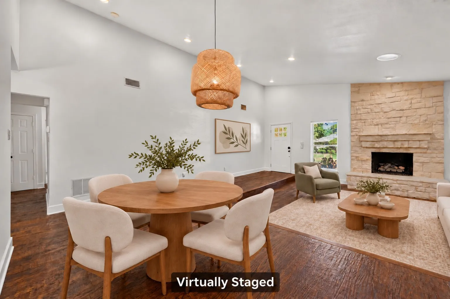 An inviting layout connects the dining and living areas, with a striking stone fireplace and nearby beverage storage space for easy entertaining. Virtually staged.