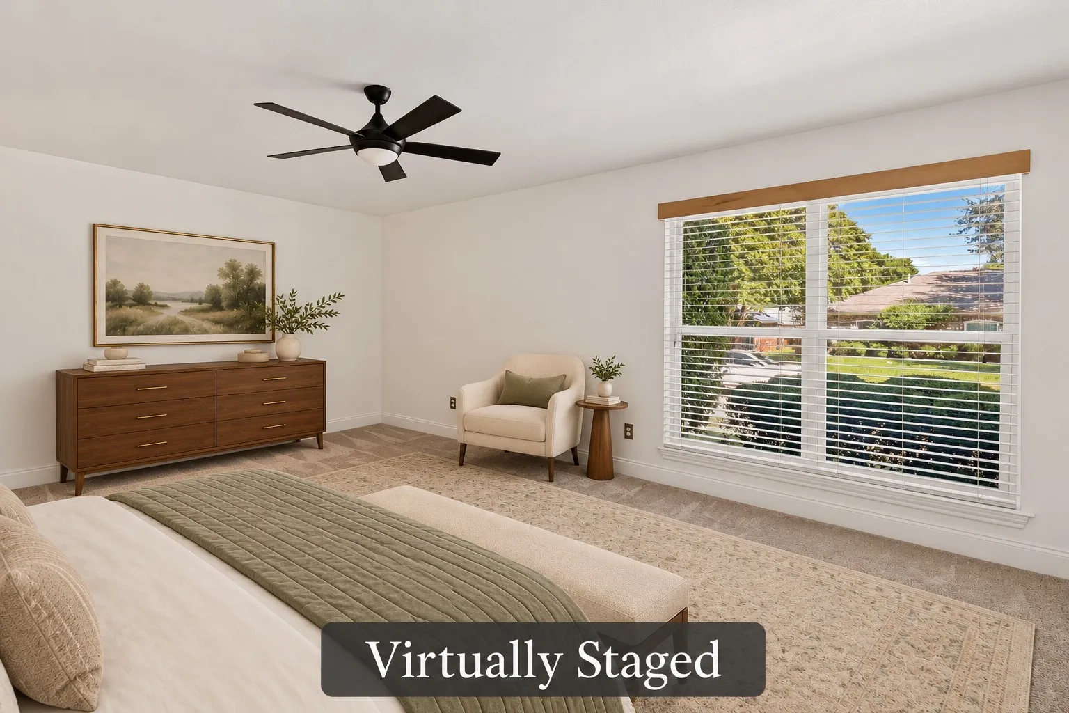 A large window fills the primary bedroom with natural light, while generous floor space allows for a cozy reading corner. Virtually staged.