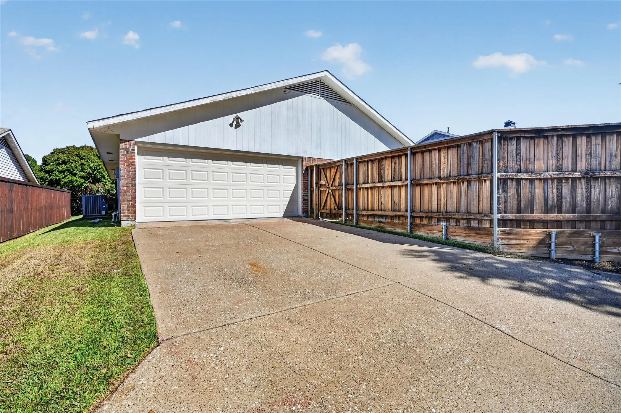 A rear-entry two-car garage and generous driveway provide convenient parking, with gated access to the backyard.