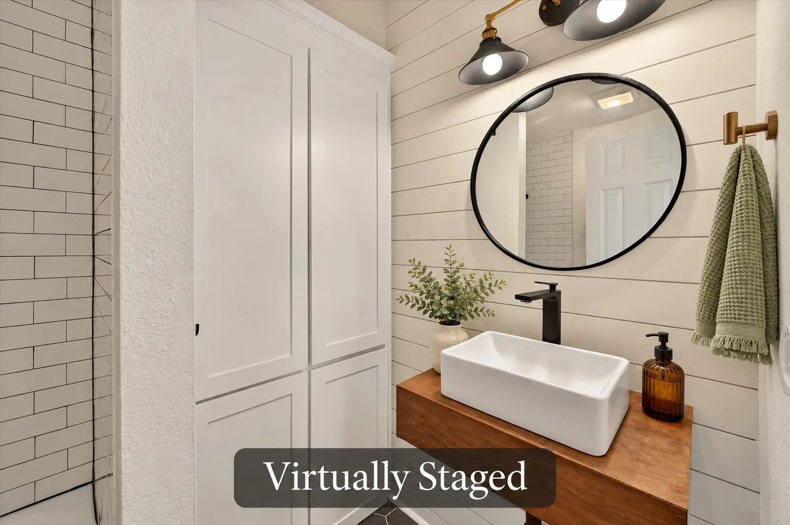 The hall bath blends character and function with a vessel sink, wood vanity top, shiplap detailing and tall storage cabinetry. Virtually staged.