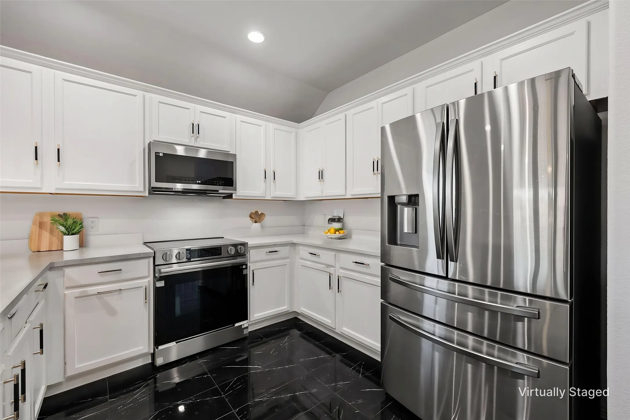 White shaker cabinetry, stainless steel appliances, black marble-look flooring, light-toned countertops, and a white subway tile backsplash