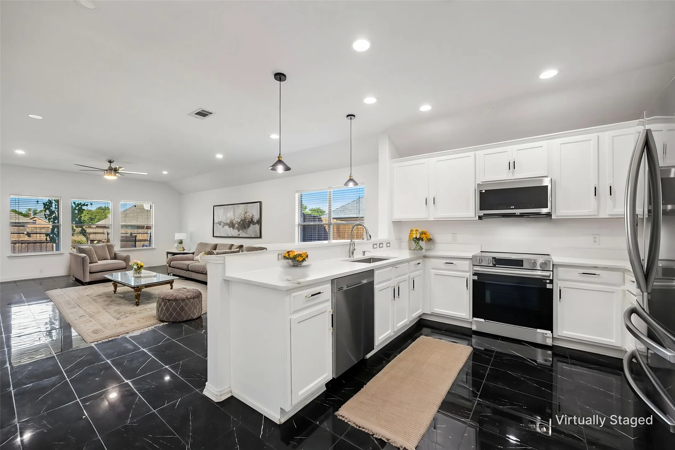 Kitchen featuring stainless steel appliances, white cabinetry, and white countertops