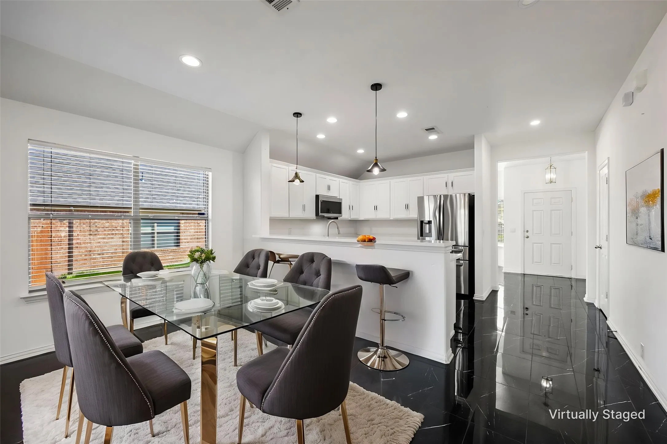 Contemporary kitchen with white cabinetry, stainless steel appliances, recessed lighting, and a breakfast bar