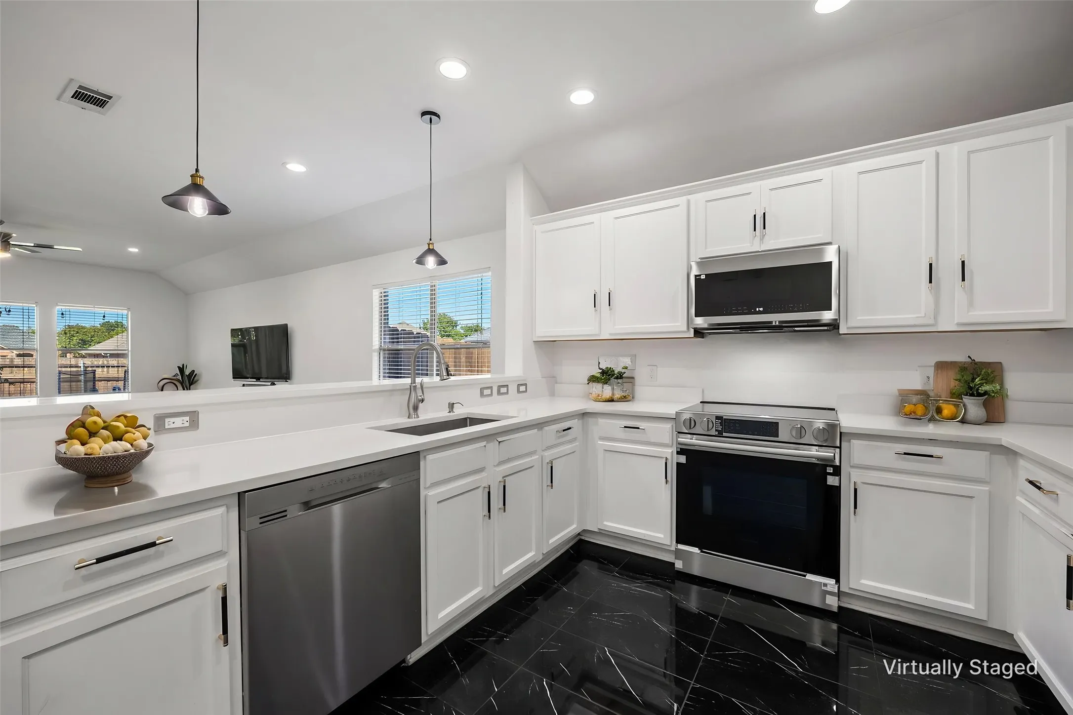 White cabinetry, stainless steel appliances, black tile flooring, recessed lighting, and a kitchen peninsula with pendant lighting